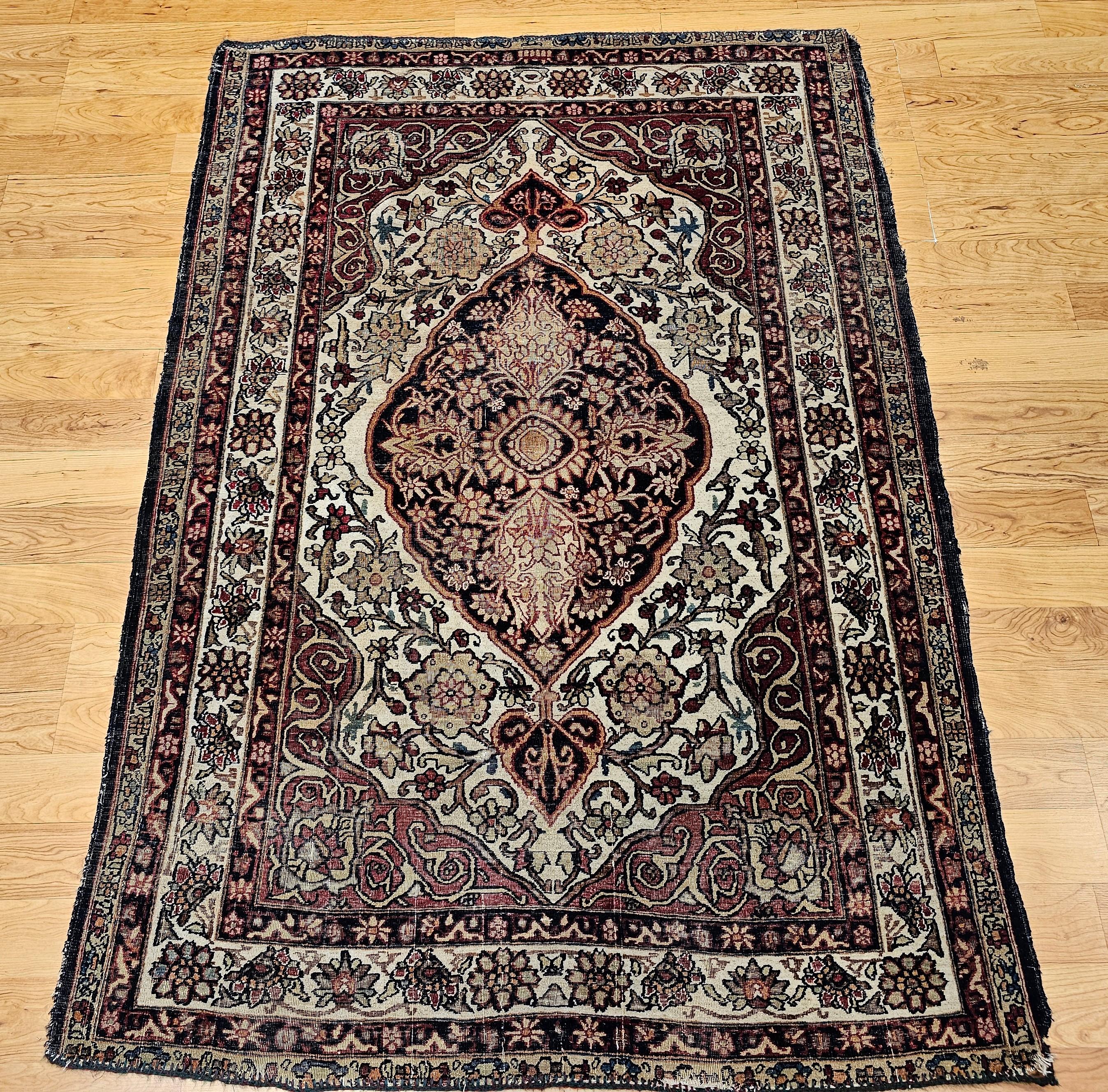Magnifique design avec une merveilleuse palette de couleurs. Tapis persan Kerman Lavar à motif floral de grand format datant de la fin des années 1800. Le champ principal est de couleur ivoire avec un médaillon central de couleur bleu marine ou bleu