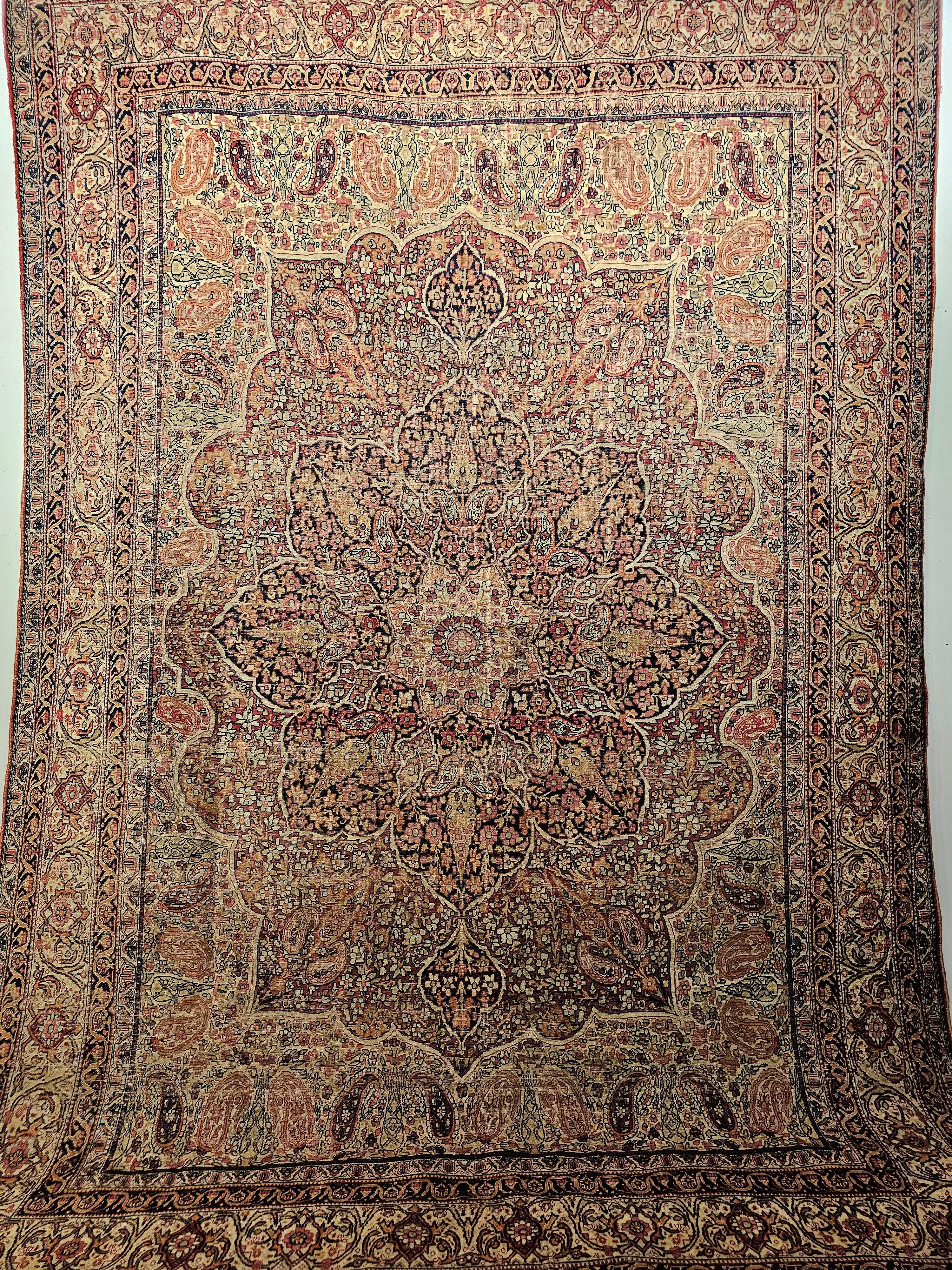 Late 19th century Persian Kerman Lavar room size rug in a floral and paisley design in ivory, red, pale yellow, and midnight blue colors.  The rug has a gorgeous design and wonderful color combination.  The rug has a central medallion in navy blue