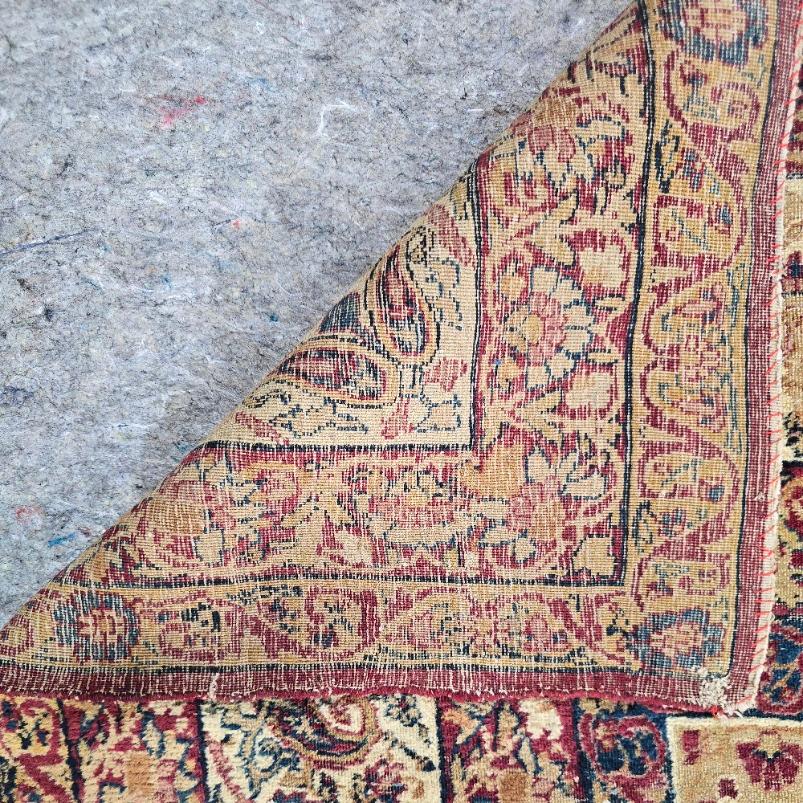 Ajoutez une touche d'élégance intemporelle à votre espace avec cet ancien tapis persan Kirman, un exemple époustouflant de l'art persan noué à la main. Fabriqué à Kirman, en Perse, ce tapis en laine de 9 x 13 présente un médaillon central élaboré,
