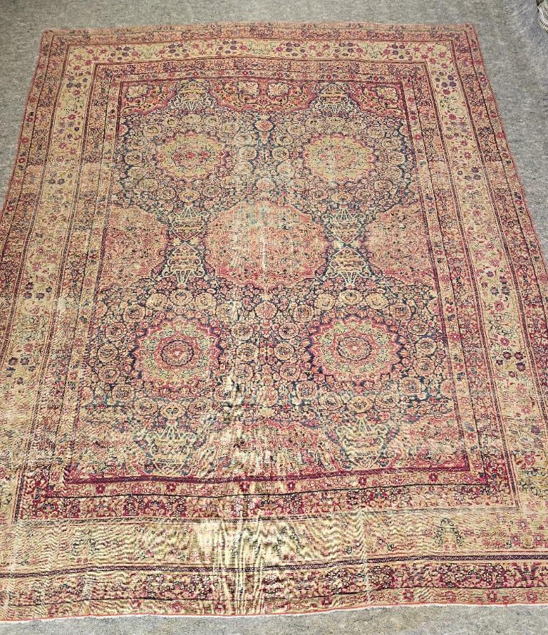 Aggiungi un tocco di eleganza senza tempo al tuo spazio con questo antico tappeto persiano Kirman, un esempio mozzafiato di arte persiana annodata a mano. Realizzato a Kirman, in Persia, questo tappeto in lana 8,8 x 11 presenta un elaborato