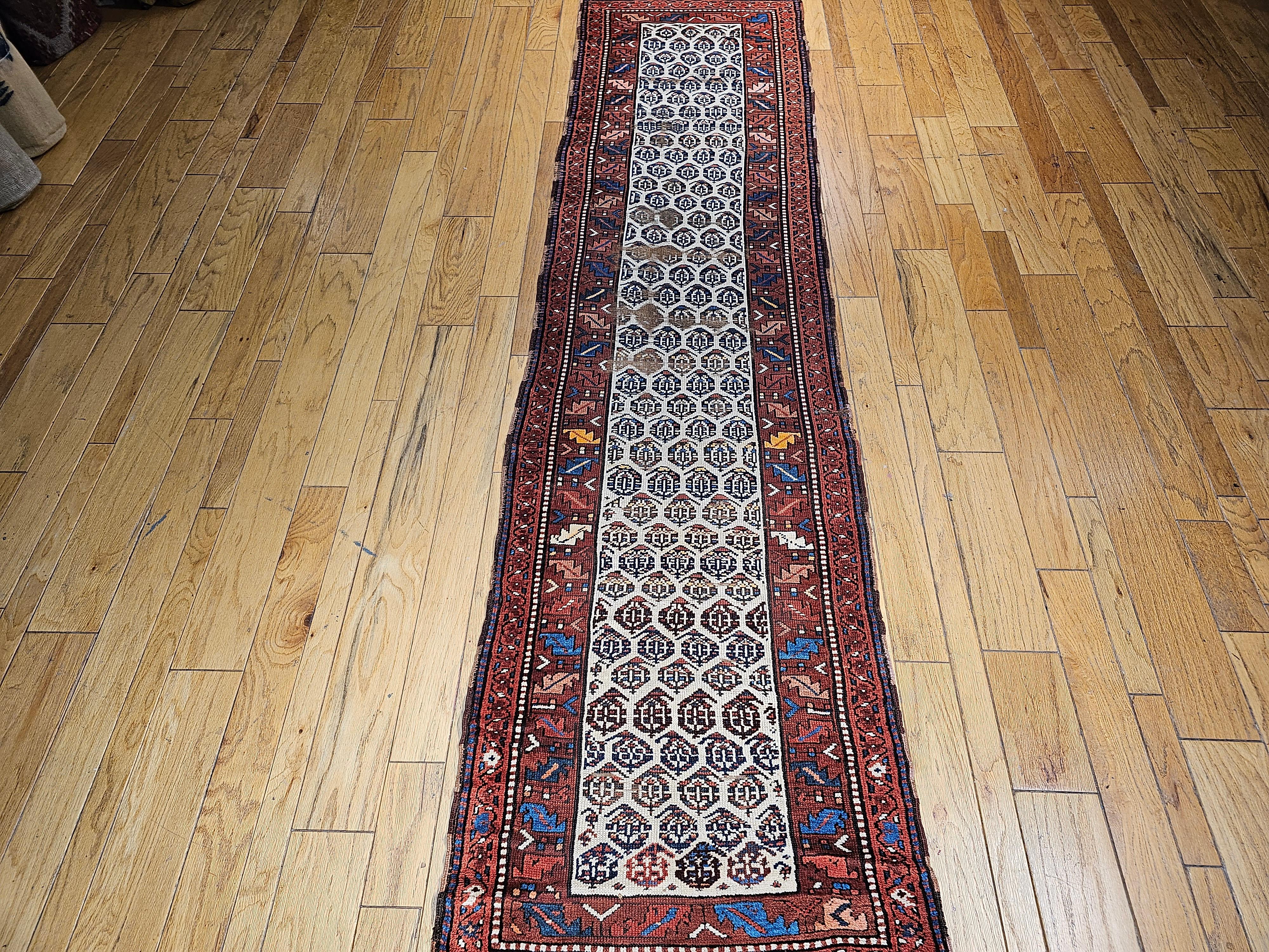 Runner persiano vintage Bidjar del quarto trimestre del XIX secolo.    Il motivo paisley allover è inserito in un campo color crema chiaro.  Il bordo color mattone contiene un disegno di foglie nei colori rosso, verde, blu e rosa. Il campo è in