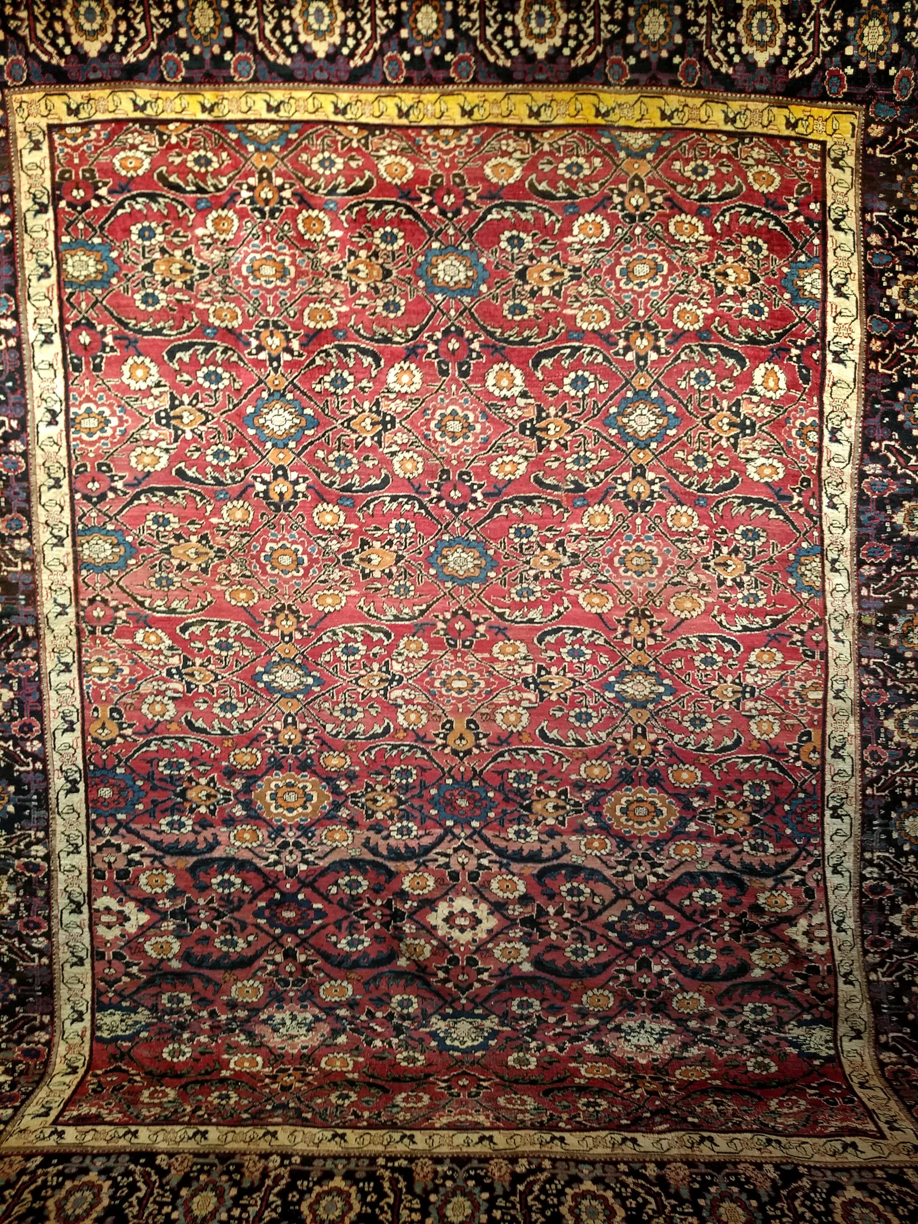 Beautiful antique Ziegler Mahal Sultanabad carpet from the last quarter of the 1800s. It has an all-over pattern in an abrash dark red or burgundy color field that contains a large geometric pattern similar to the 19th century Persian Bidjar and