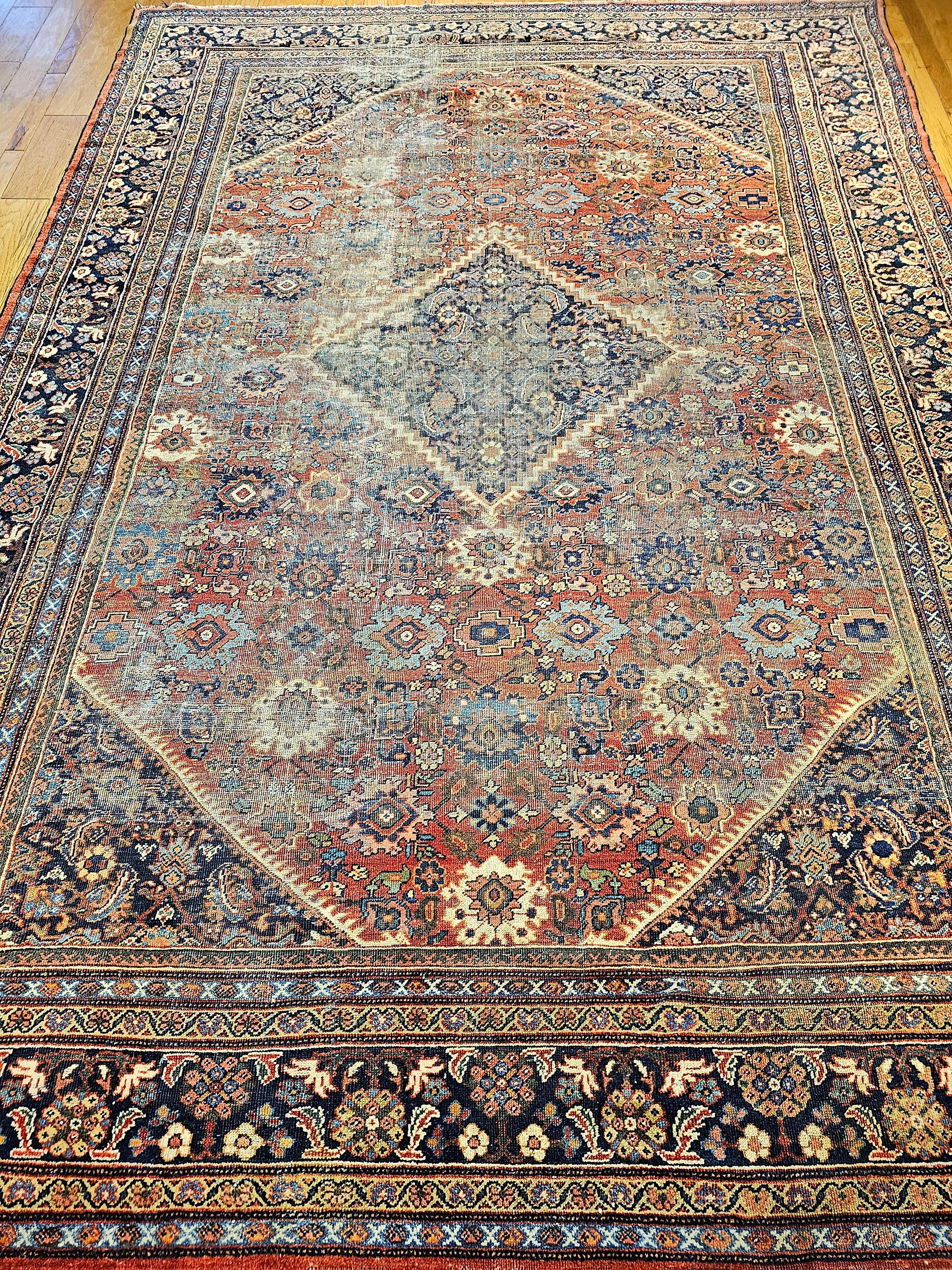 A beautiful Mahal Sultanabad rug from the late 1800s.   A fine artisan workshop Persian rug from the late 19th century.   The field is in a brick red color with large geometric forms throughout the field in colors of red, pink, green, blue, and