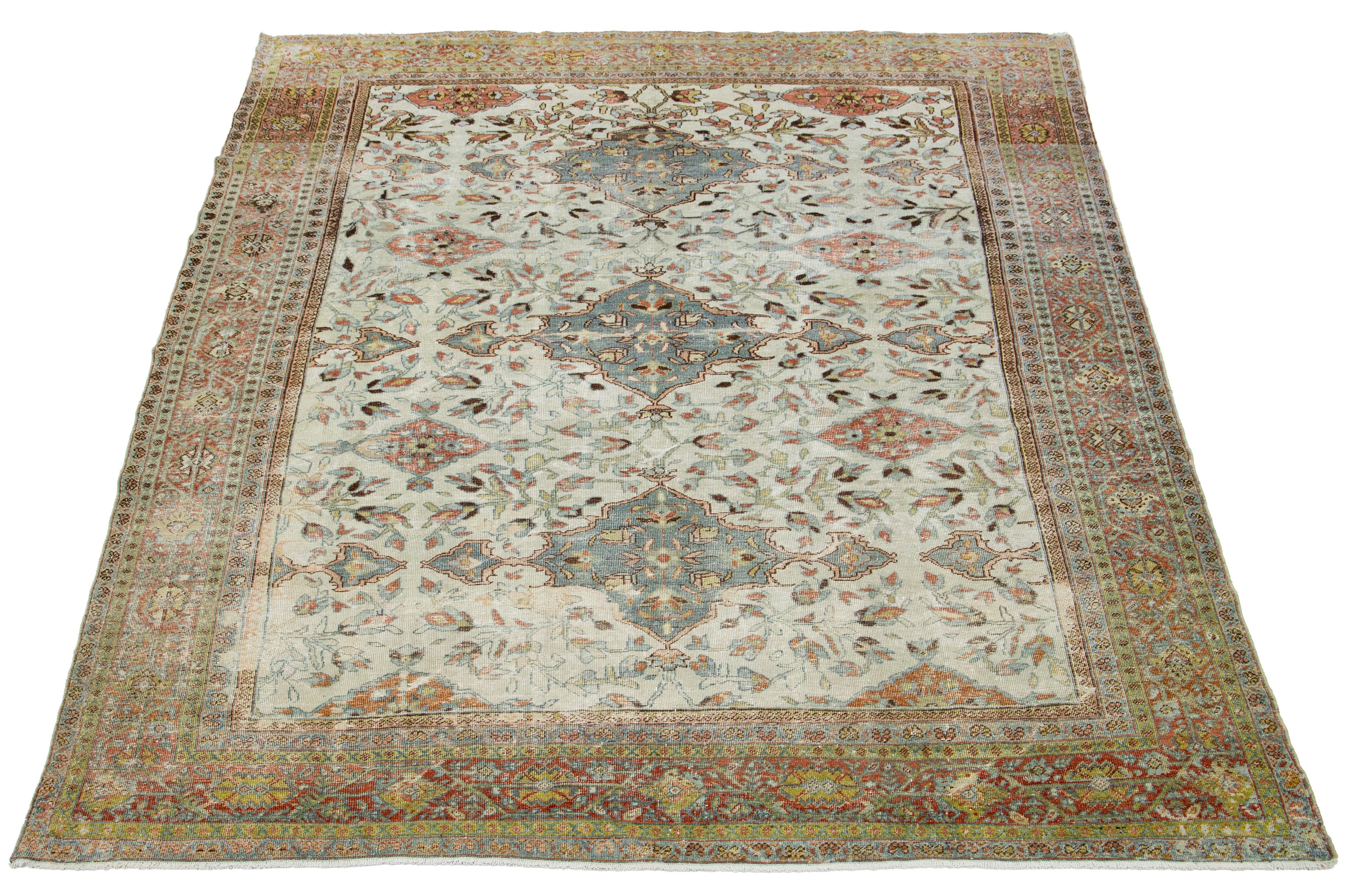 This is a beautiful Antique Mahal hand-knotted wool rug with a beige-colored field. The floral motif of this Persian rug is adorned with green, rust, and brown hues.

This rug measures 9' x 11'6