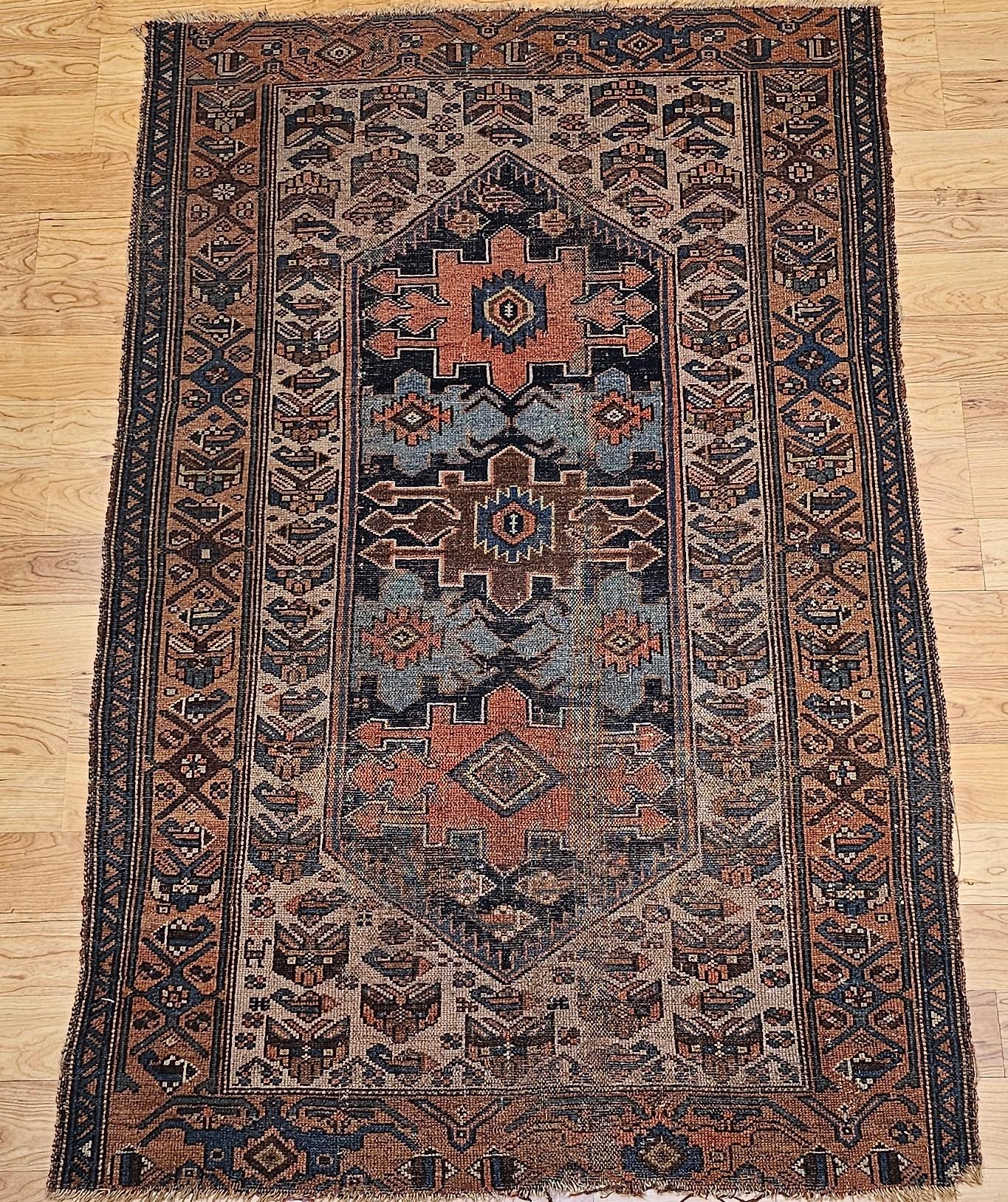 Vintage Persian Malayer area rug in an allover geometric pattern set on an ivory background with a brick red  border and accents colors in turquoise, brown, green, and red circa the late 1800s.    The larger format geometric medallion designs in the