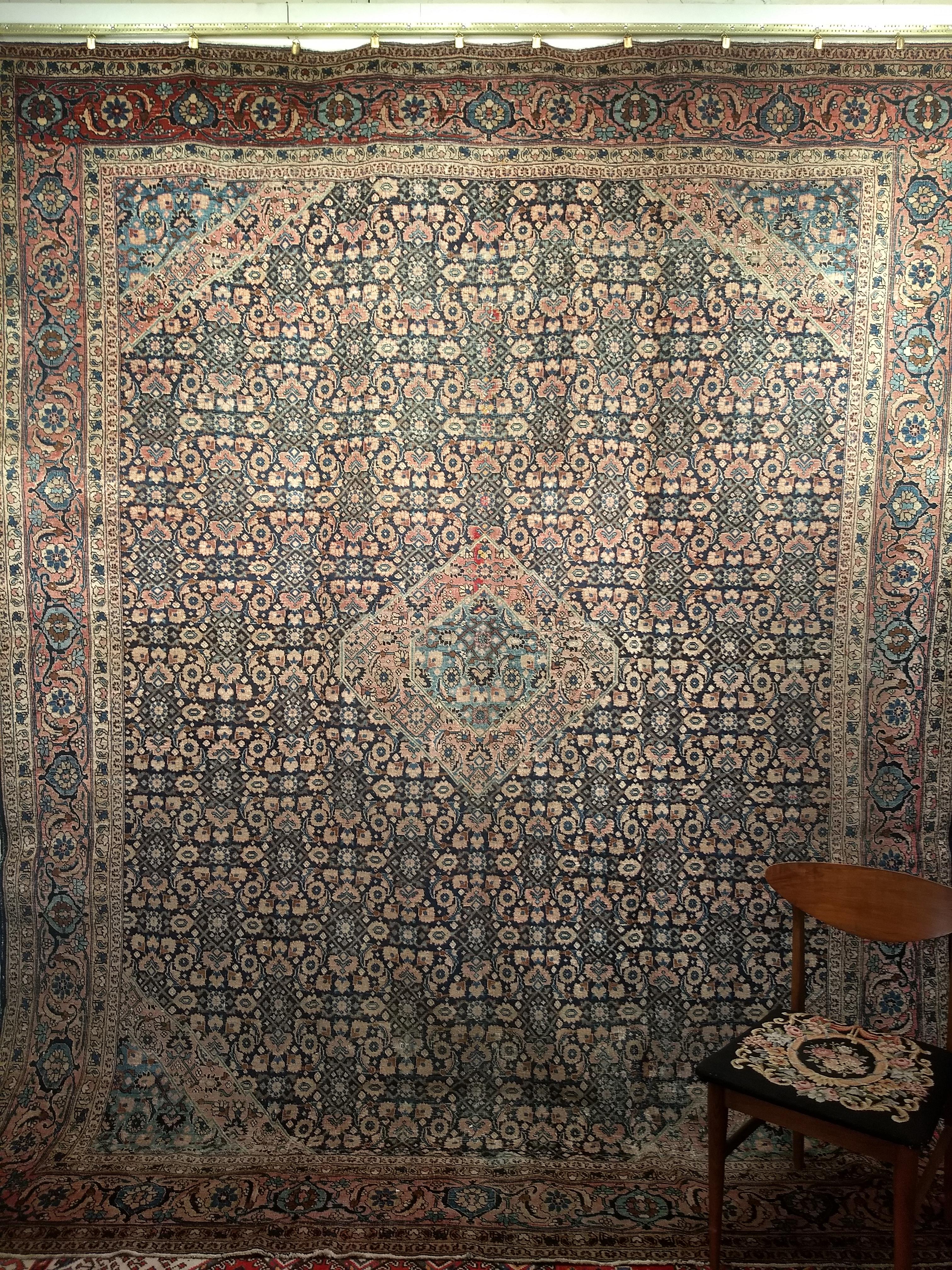 A beautiful Persian Tabriz  in an all-over Herati pattern from the late 1800s. The midnight blue background has a small central medallion in pale red and baby blue.  The border is a beautiful abrash red color with tones of the rose’ with designs in