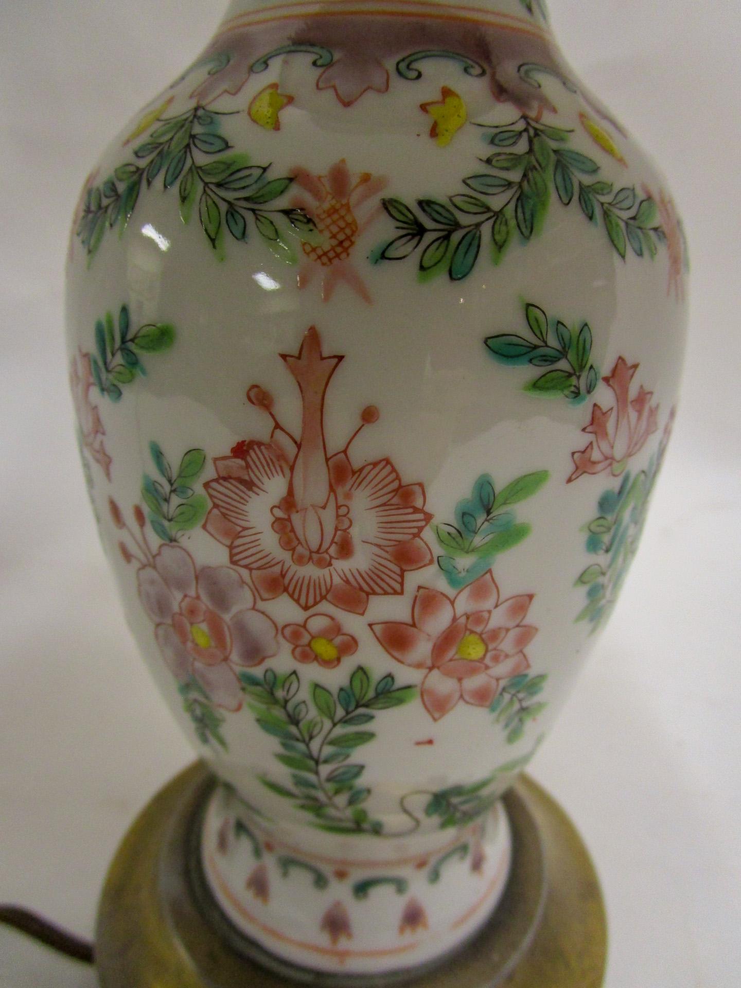 Late 19th century Chinese Export porcelain lamp in a nice petite size. Featuring a 7 inch tall fine porcelain vase in a pink and green floral design, it sits atop a brass footed base. The new silk shade measures 8 inches tall x 11 inches wide x 8.50
