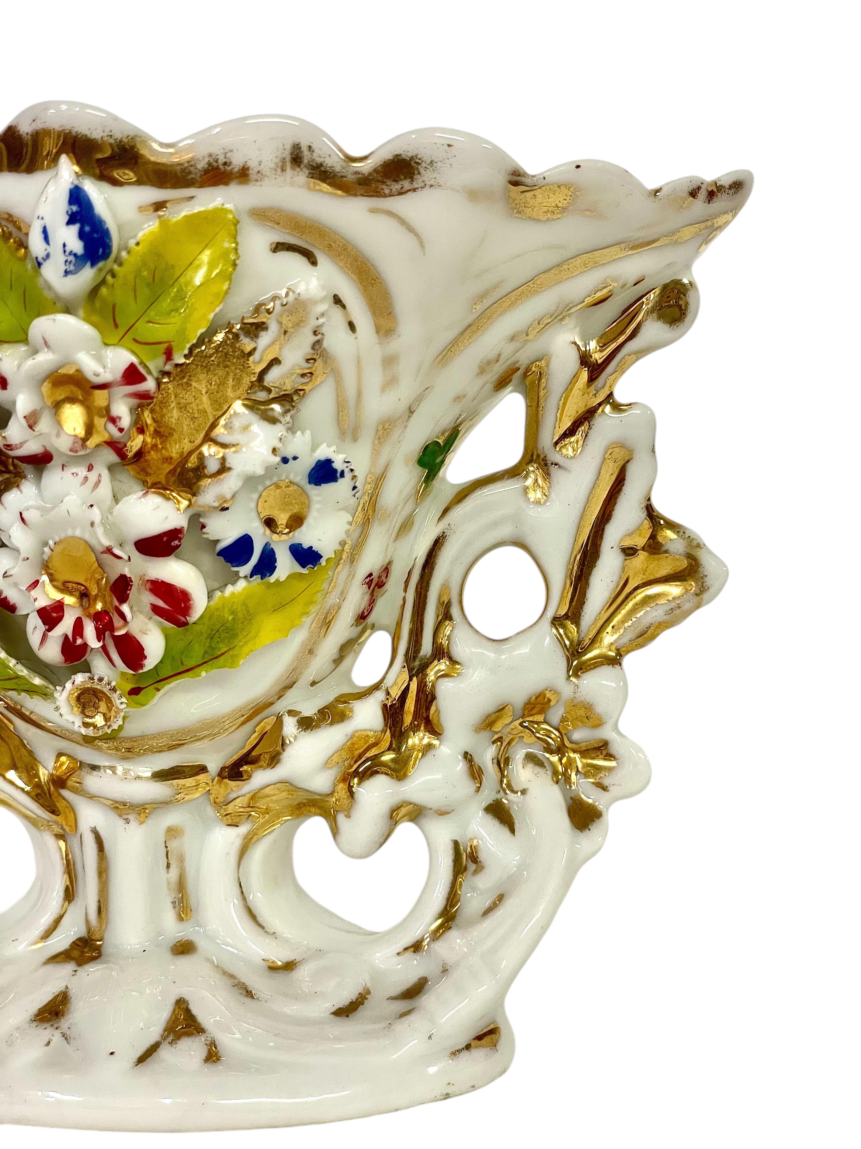 Bellissimo vaso francese del XIX secolo. Questo elegante pezzo di porcellana presenta un disegno floreale finemente realizzato, accentuato da vivaci dettagli dipinti a mano e sottolineato da lussuosi accenti dorati. I suoi intricati trafori e la sua