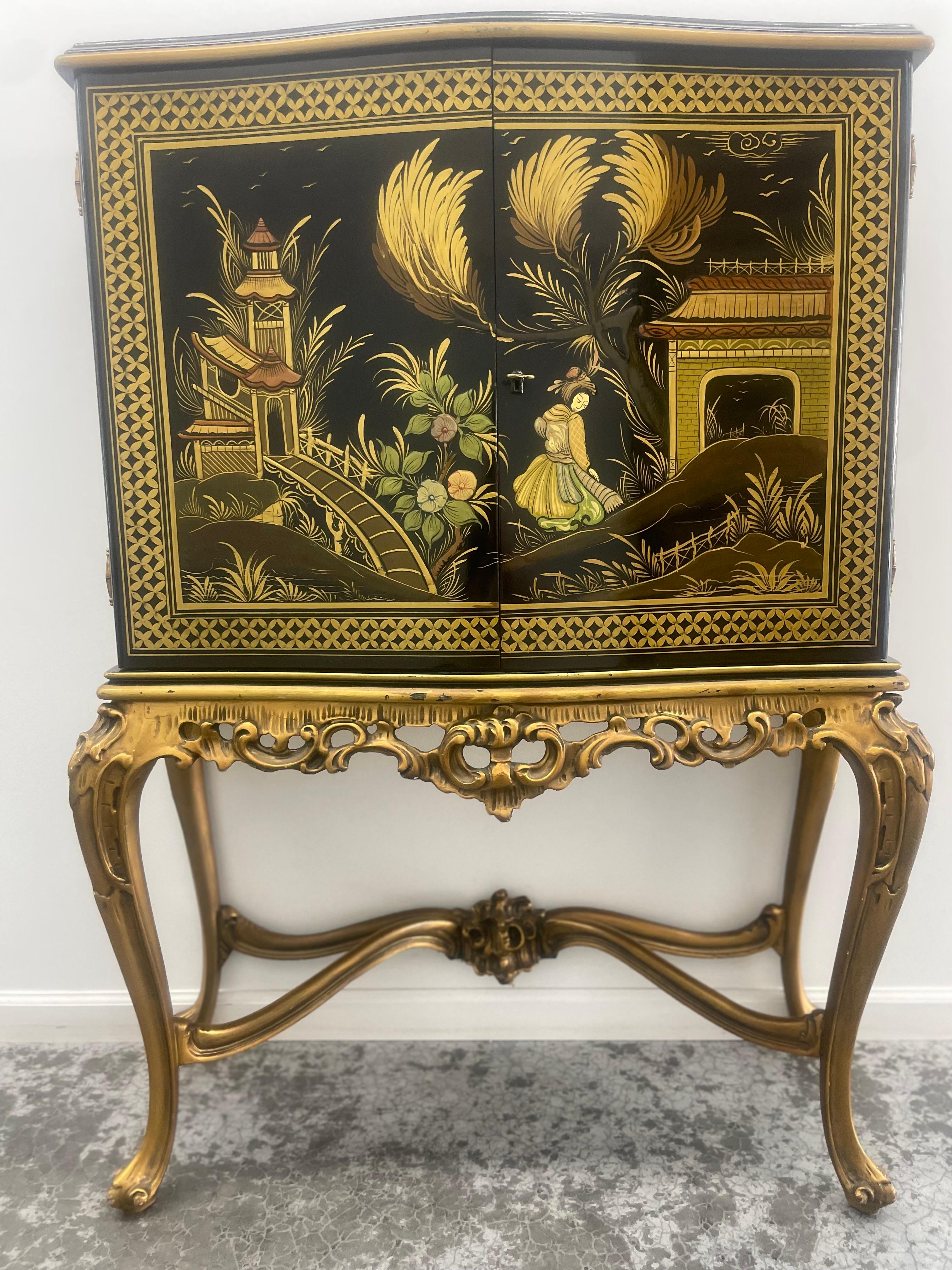 Sourced From an Estate in Saint-Malo, France, this is a Stunning 19th Century Petite Rococo Style Asian Dry Bar. It has Chinoiserie Hand Painted Scenes. 

This Chinoiserie-Style Liquor Cabinet is on a beautiful ornate stand. It is solid wood, with