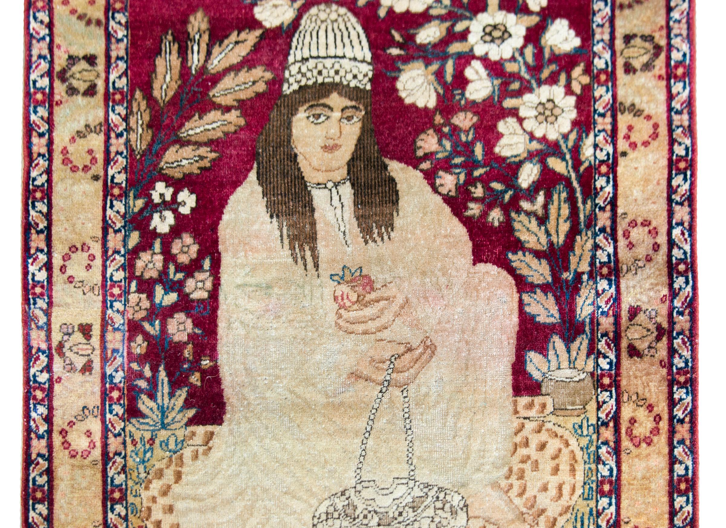 A stunning late 19th century Persian Lavar Kirman pictorial rug depicting a seated Gonabadi Dervish, a Sufi order originating in the 14th century whose followers believe in peace, security, equality, and shun violence and politics.  The Dervish is