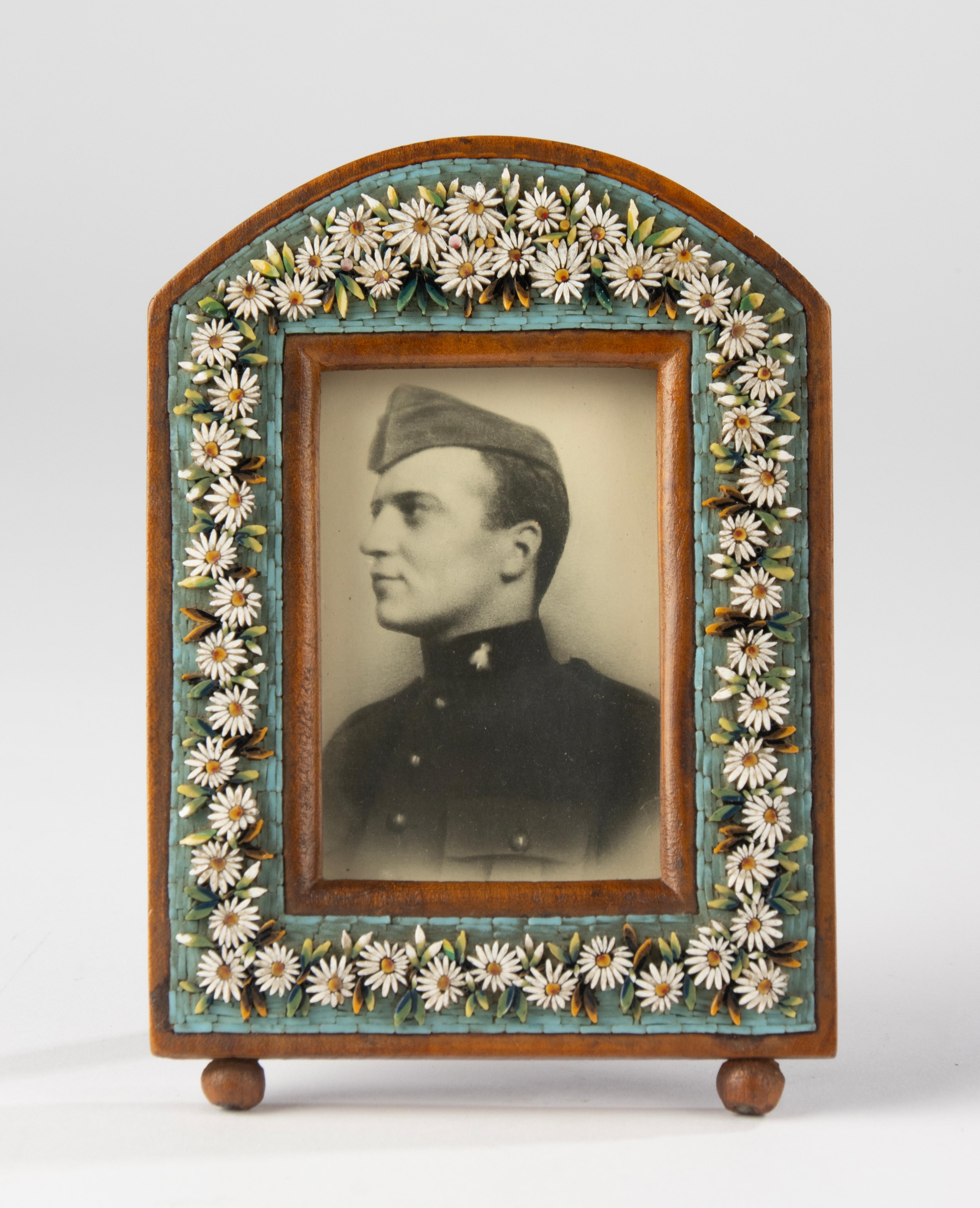 A beautiful antique photo frame, dating from the end of the nineteenth century, beautifully decorated with micro mosaic.
They are very small stones of colored glass, a typical technique from Venice.
The base of the photo frame is walnut.
The photo