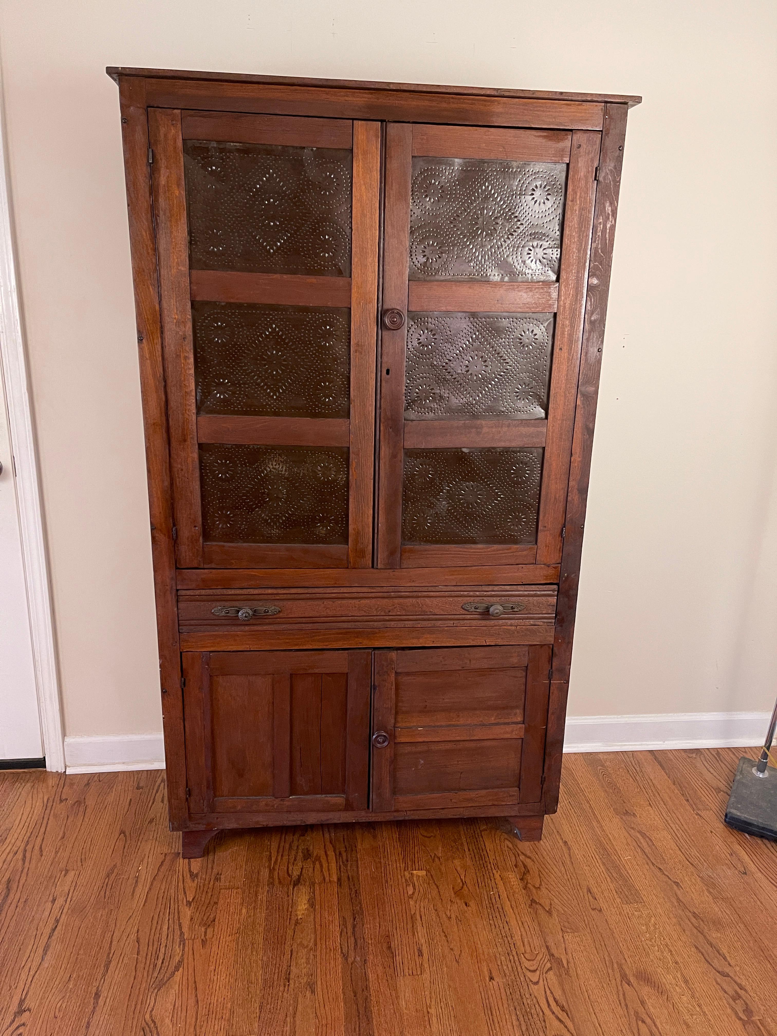 Very old, but still sturdy, South Carolina pie safe.
More tin panels than is usually found.
Made of various light colored woods.
Never painted.
Ten beautiful punched tin panels.
One drawer.
Lower storage also.
Original shelves are lost ; replaced by