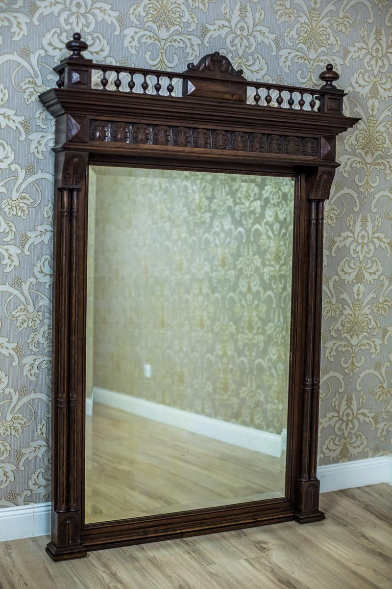 We present you this mirror of a grand size in an oak frame in the Eclectic style. This piece of furniture is circa fourth quarter of the 19th century.
The mirror is flanked by double columns, and is topped with an ornament line with a gallery and