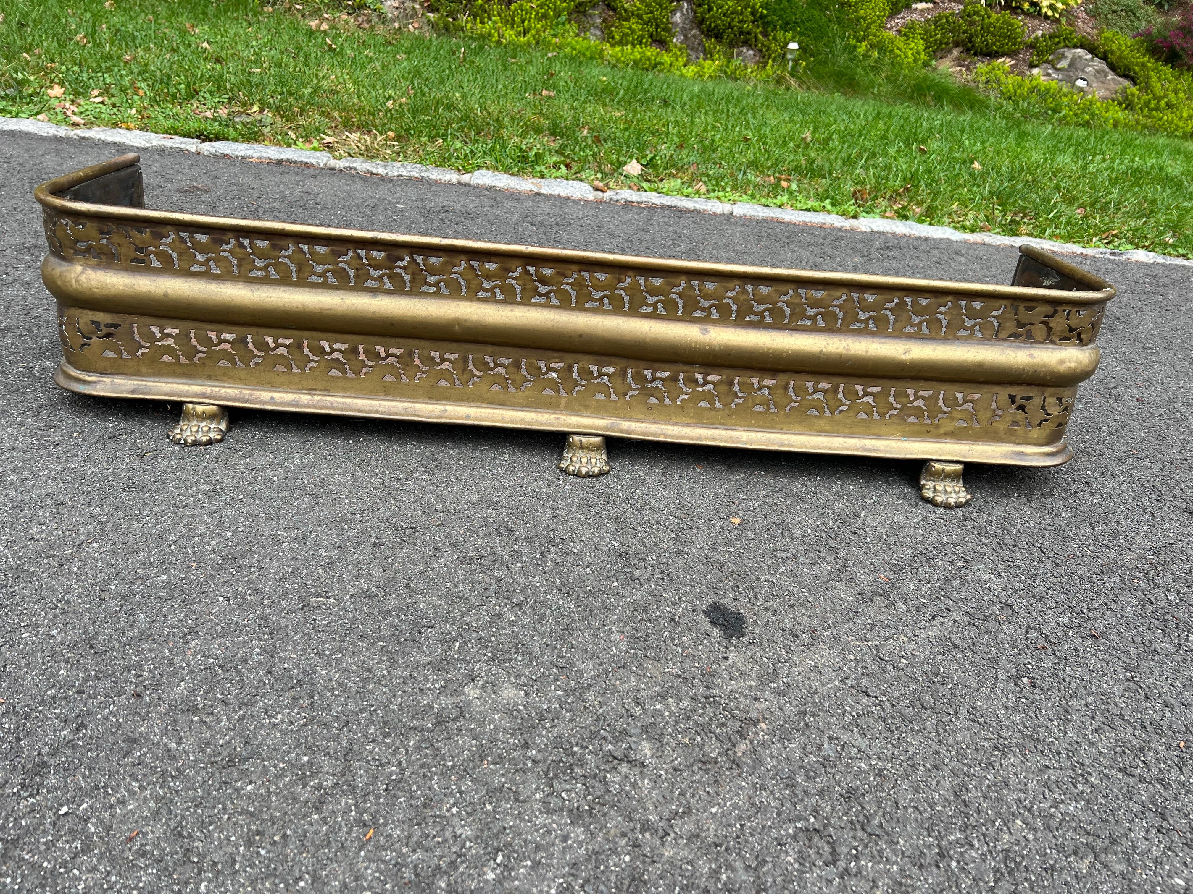 19th Century Pierced Brass Fireplace Fender. Classic lion paw feet with pierced reticulated floral design. George III style.