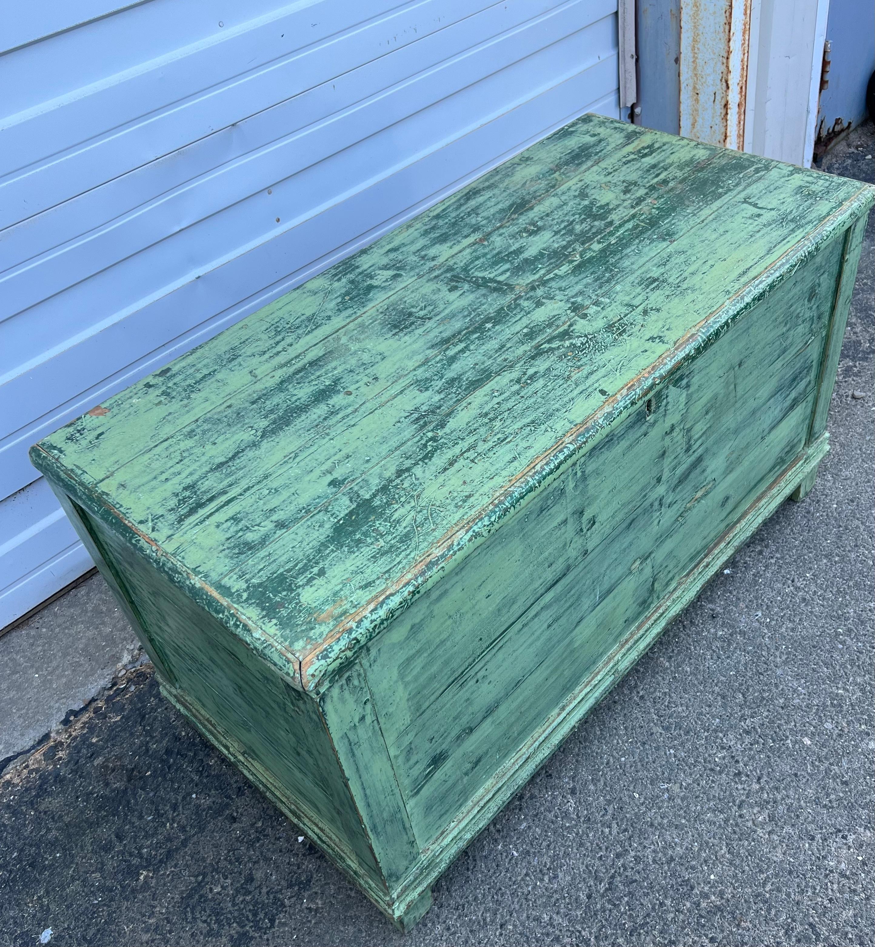19th century pine blanket chest with block feet.  In early green paint over original dark green paint. Unfinished on back.