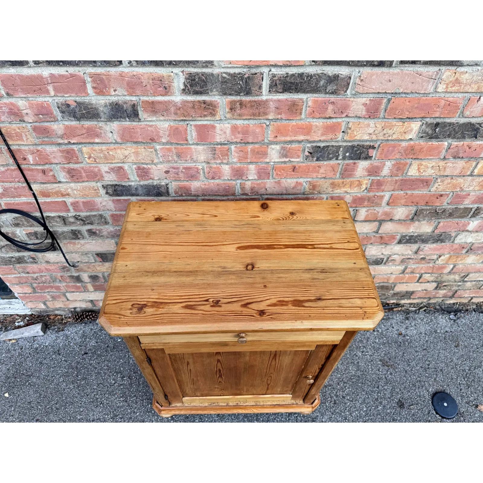 This is a beautiful little English side table! This natural wood table has one drawer and one door storage with shelving. Pine is so popular in any form right now, and this is no exception with a beautiful tone and lovely patina. This side is a
