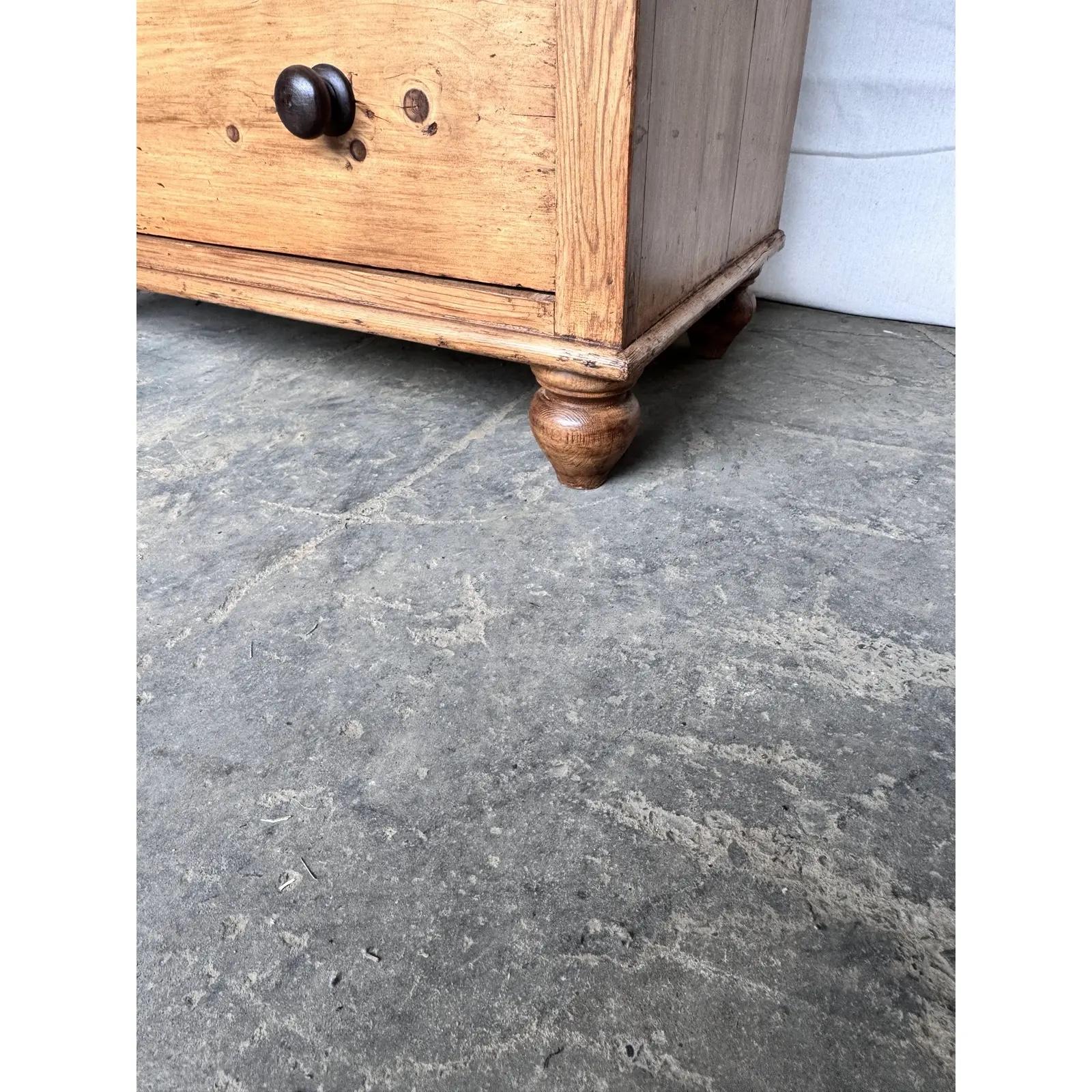 This is a lovely English pine chest! This piece dates to the 19th century and has lovely patina. The wood has a warm glow, that is accented perfectly by the darker stained knobs. This chest is two over two design with a rustic feel. This chest would