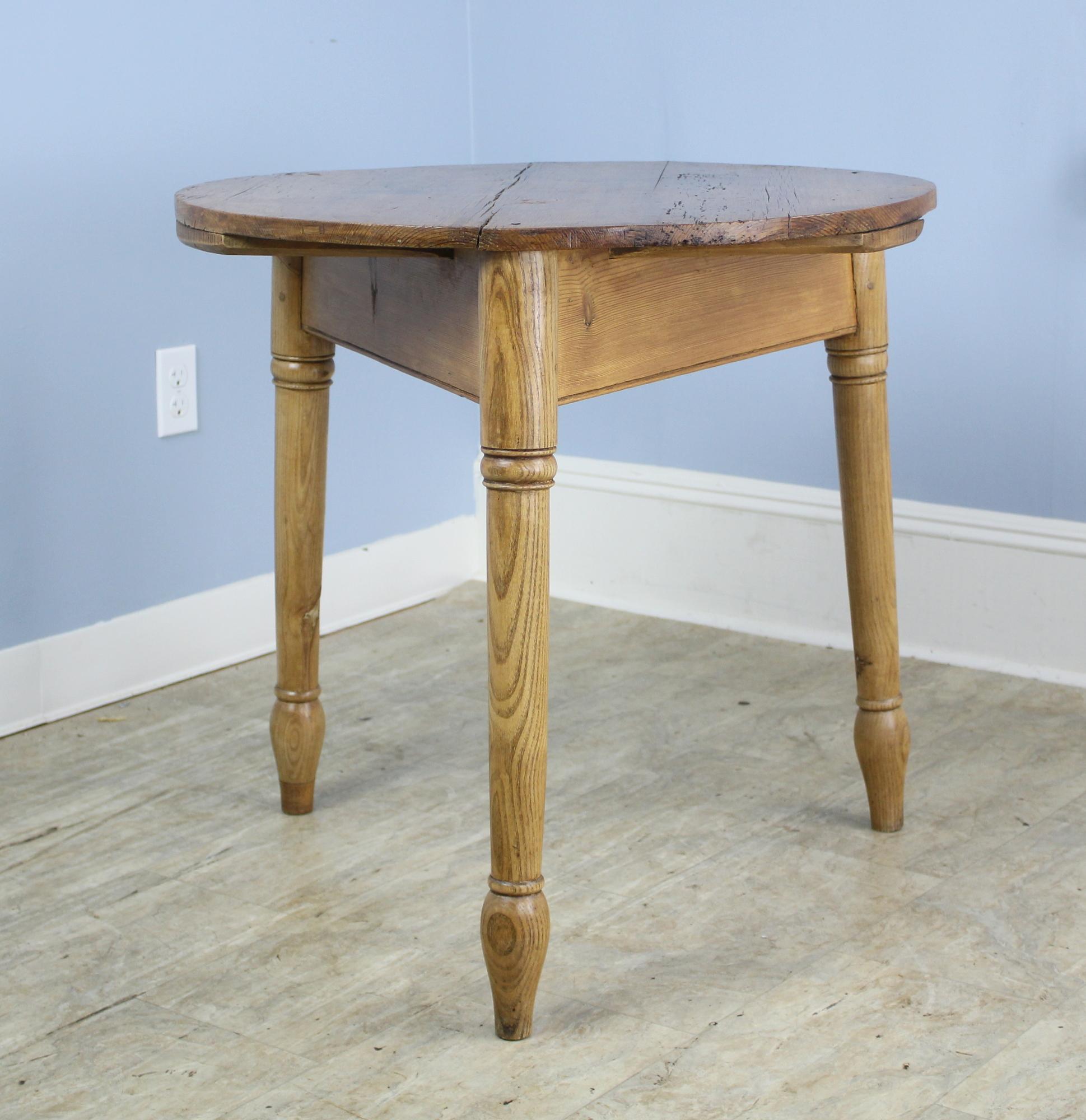 A Classic tripod base cricket table in mellow ash with a pine top. The elegant turned legs and feet set this piece apart from traditional cricket tables with these extra design notes.  Please note that the top is not a perfect circle.