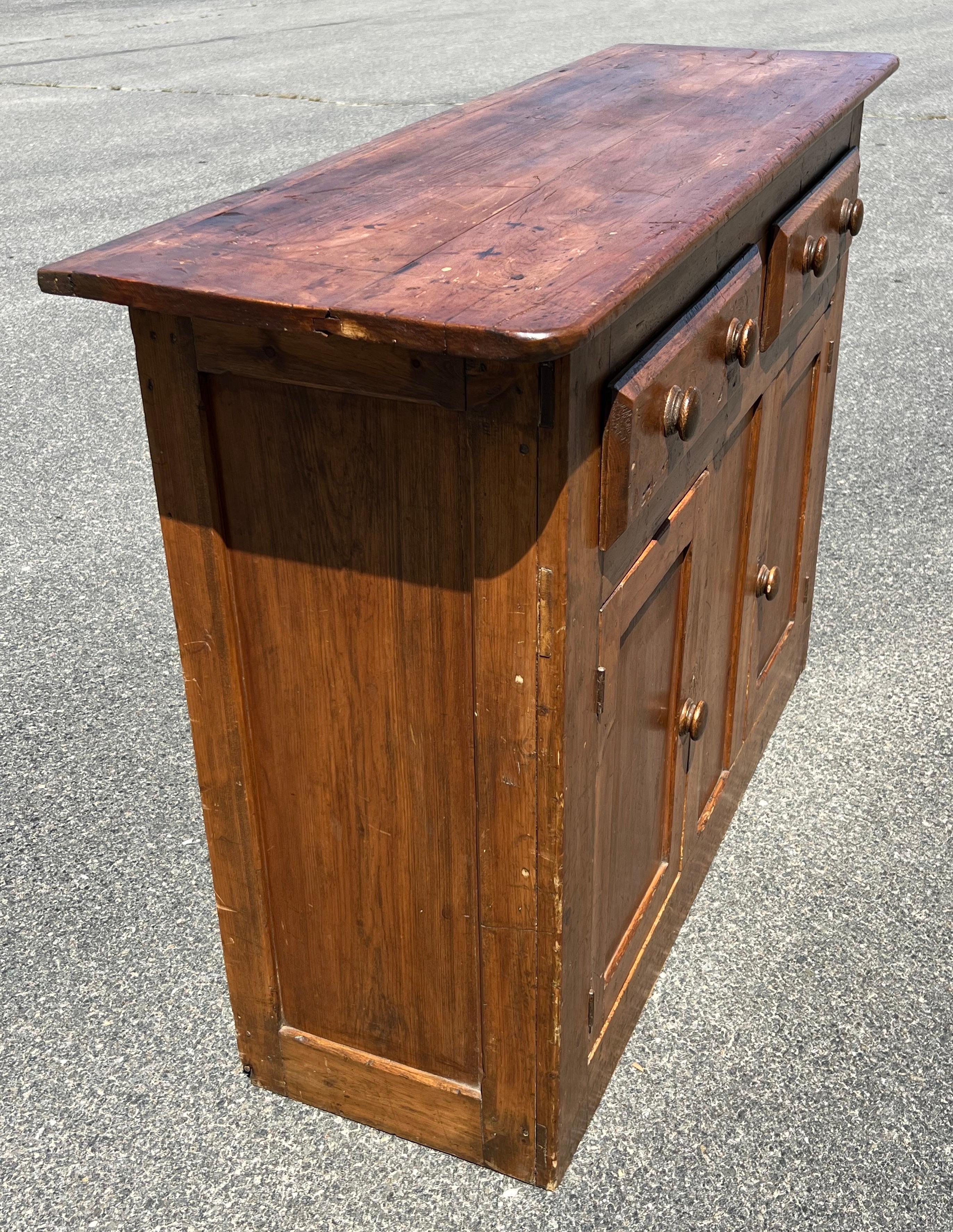 19th Century Pine Dresser Base.  Buffet with two drawers over two paneled doors which open to reveal a single shelf. 