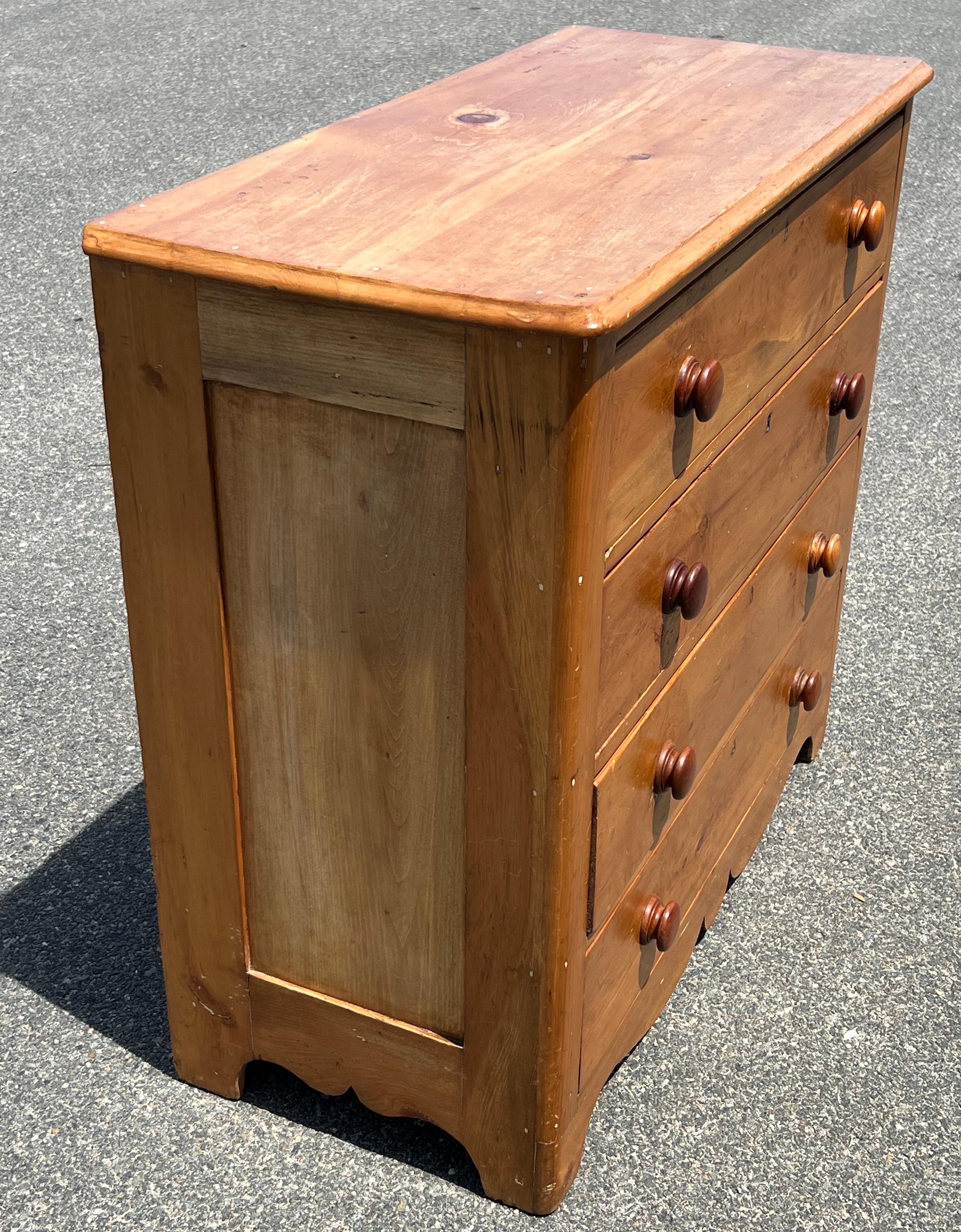 19th Century Pine four drawer chest with inlaid brass keyholes on each drawer front, turned wooden knobs, and shaped apron.