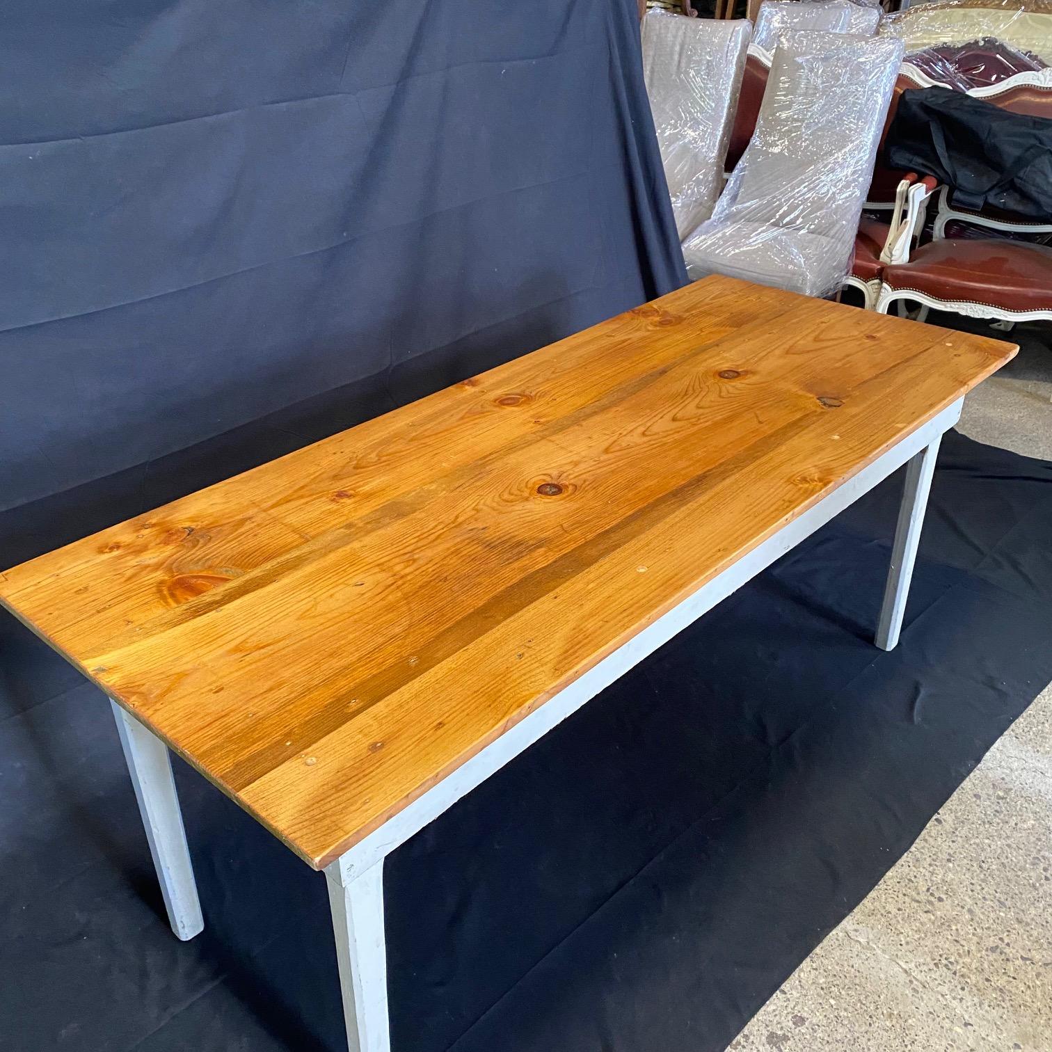 Classic primitive style dining table in the farmhouse style from an early Grange in Maine. Used since the 1800s to hold town meetings, it has been restored beautifully, yet retains its original paint on the body. All legs can be released and fold up