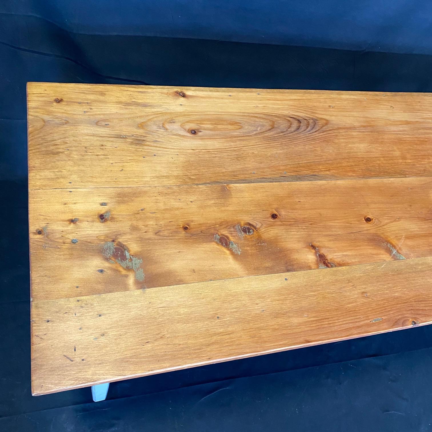 This classic primitive style dining table in the farmhouse style is from an early Grange in Maine. Used since the 1800s to hold town meetings, it has been restored beautifully, yet retains its original paint on the body. All legs can be released and
