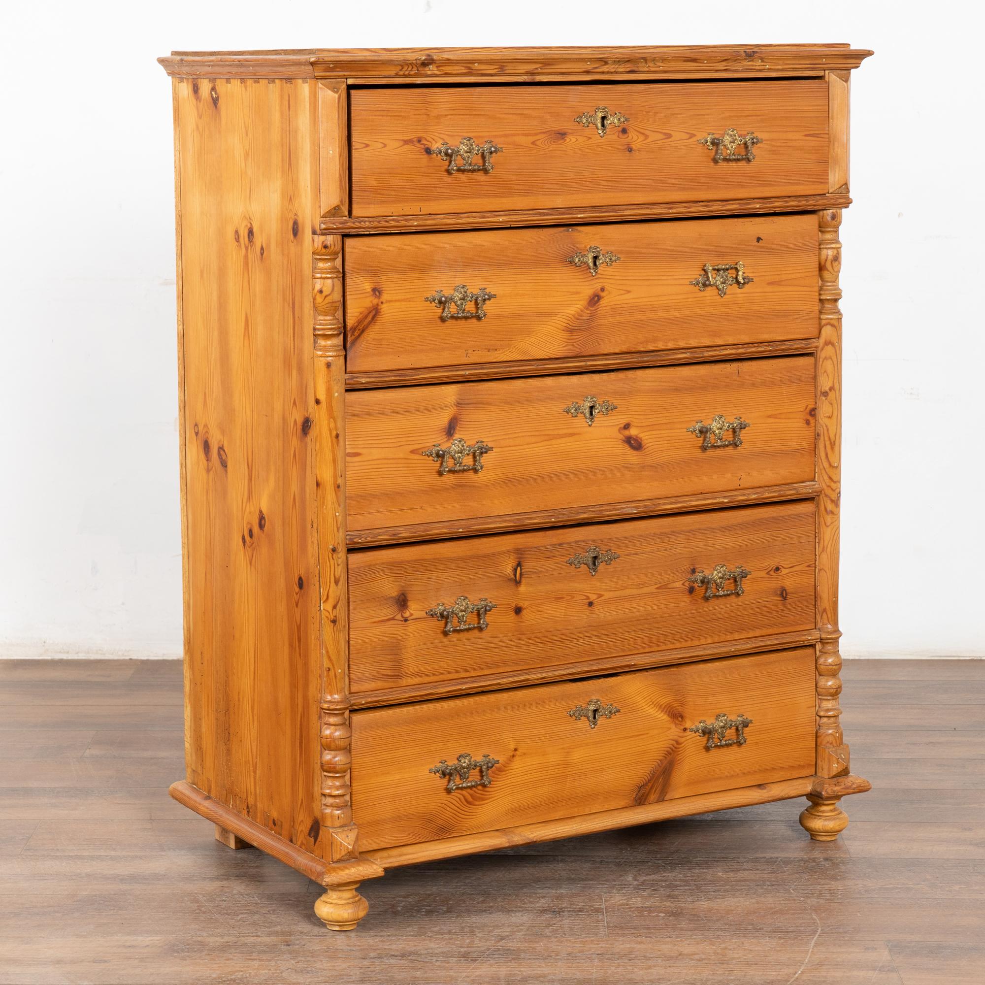 Antique Swedish pine highboy chest of five drawers with side half column detail and front bun feet.
Notice the dovetail joints and two brass pulls on each drawer which all function.
This 4' tall dresser is restored and pine has been given a wax