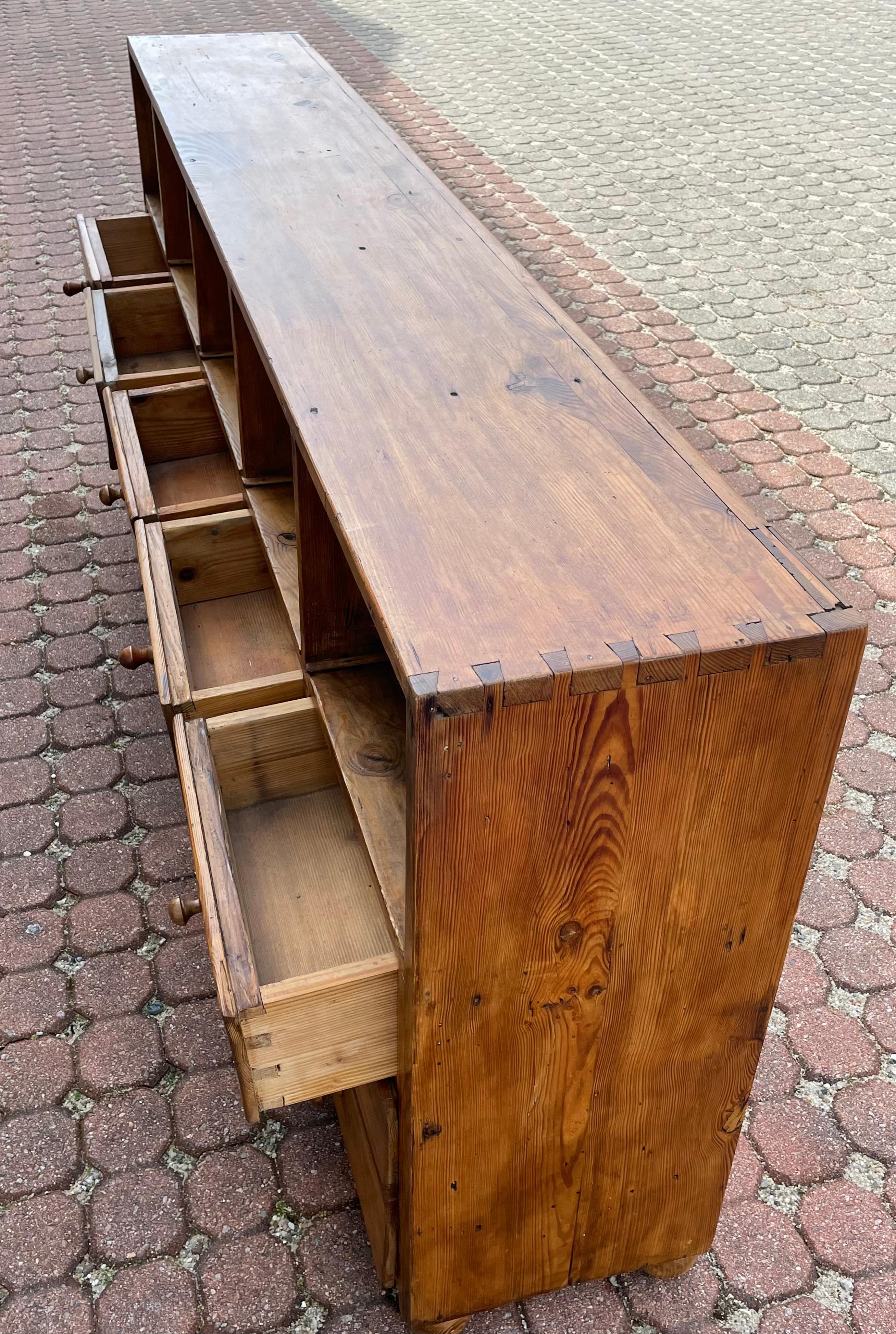 Lovely 19th Century Pine Server with five horizontal open compartments, each above three drawers with wooden knob pulls (two replaced), all resting on bun feet. Great low and shallow piece that can serve as a server or credenza with storage for