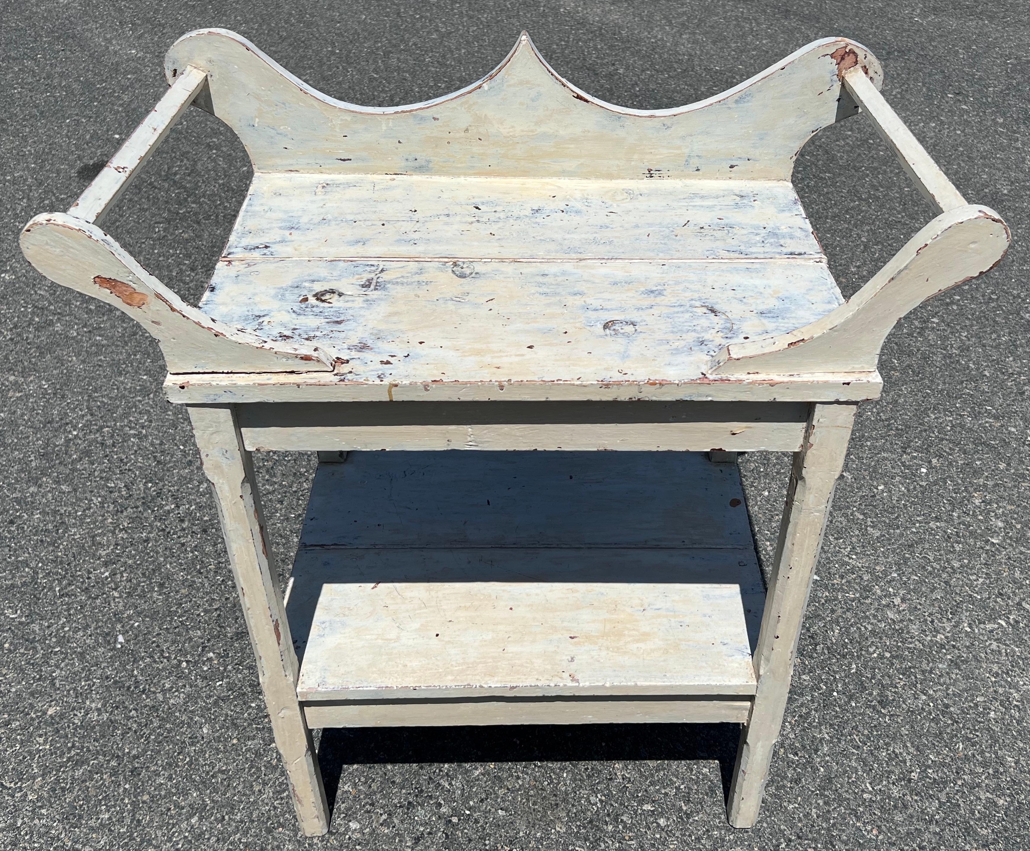 19th Century pine two tier washstand, in original white paint with nicely shaped gallery at back and spindles on each side, chamfered legs. 31 inches surface height.
