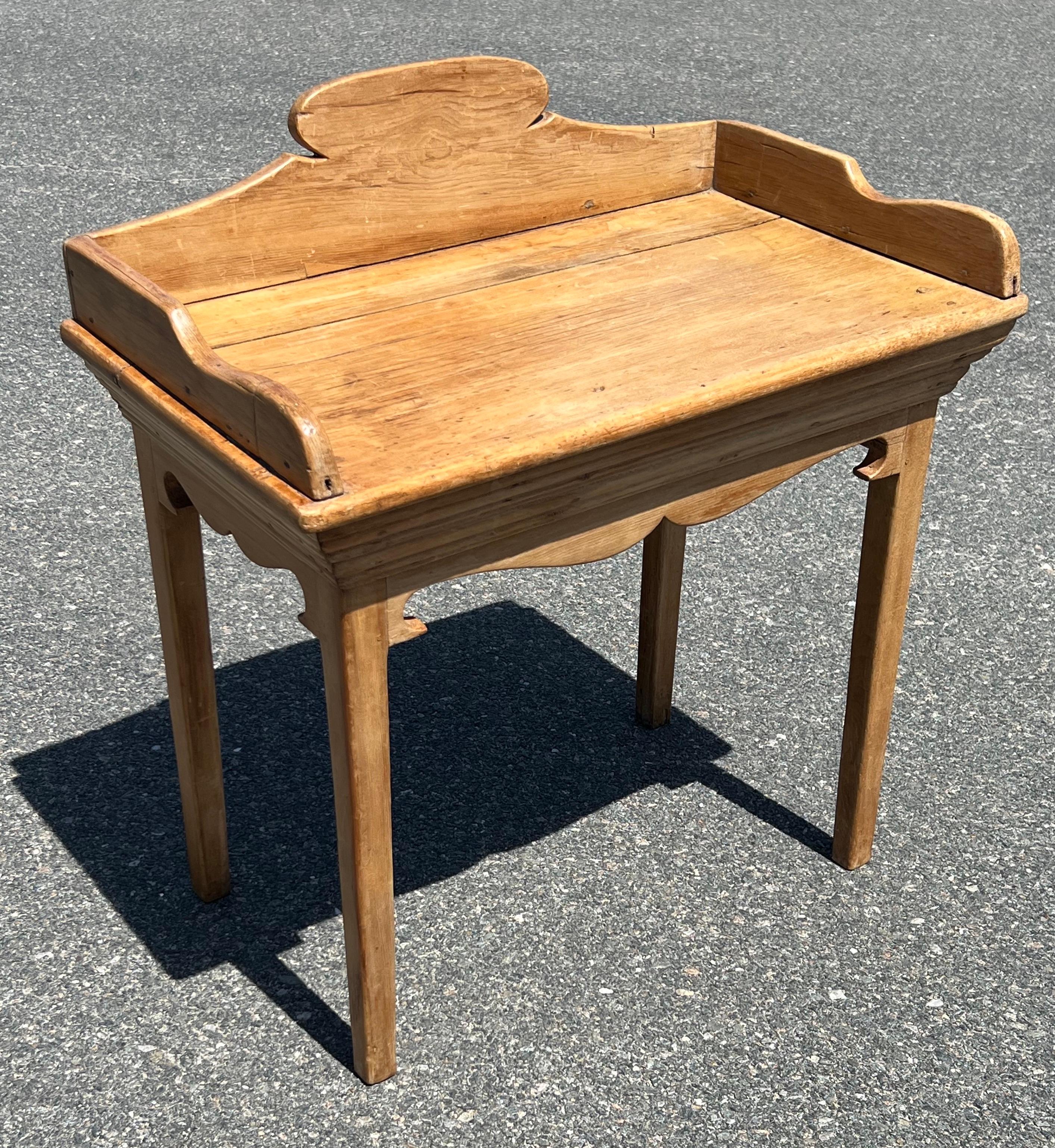 19th century Pine washstand with natural pine finish. Beautifully shaped backsplash, stepped molding under top, shaped gallery below. Surface height 26.5 inches.