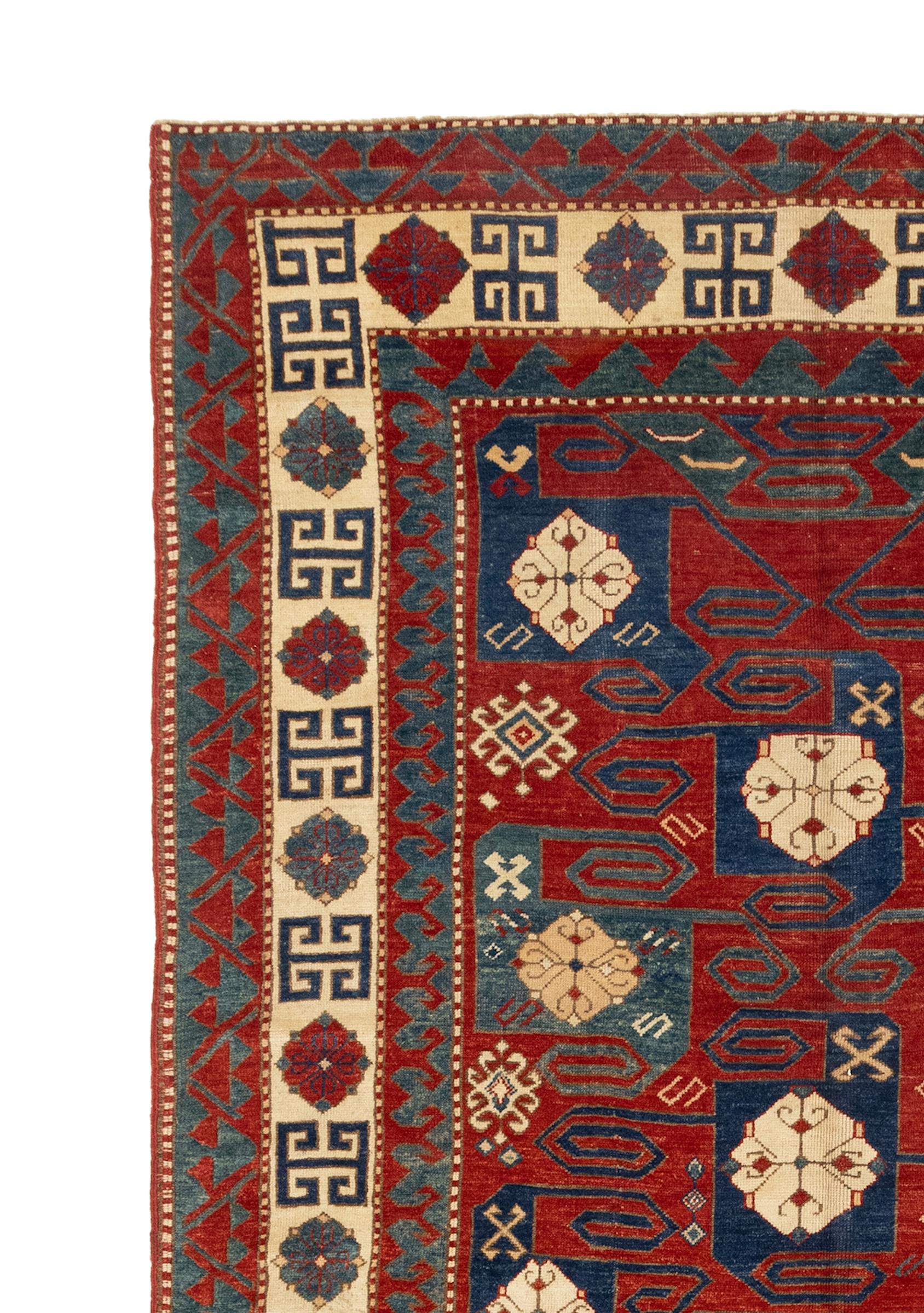 This is a beautiful pinwheel Kazak inspired from the antique Kazak pinwheel rugs of 19th century. Vivacious colors of a rich red background coming together with ivory blues, navy, and greens give the rug a unique presentation of the line work within.