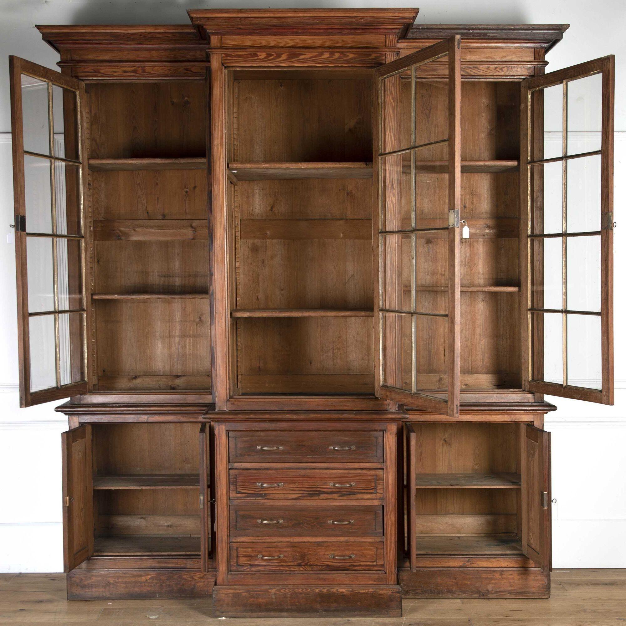 Fantastic two-part pitch pine glazed cabinet with cast-iron glazing bars.
This breakfront vitrine has three glazed doors to the top that open to reveal two spacious shelves. The base also has two sets of double doors that open to the further
