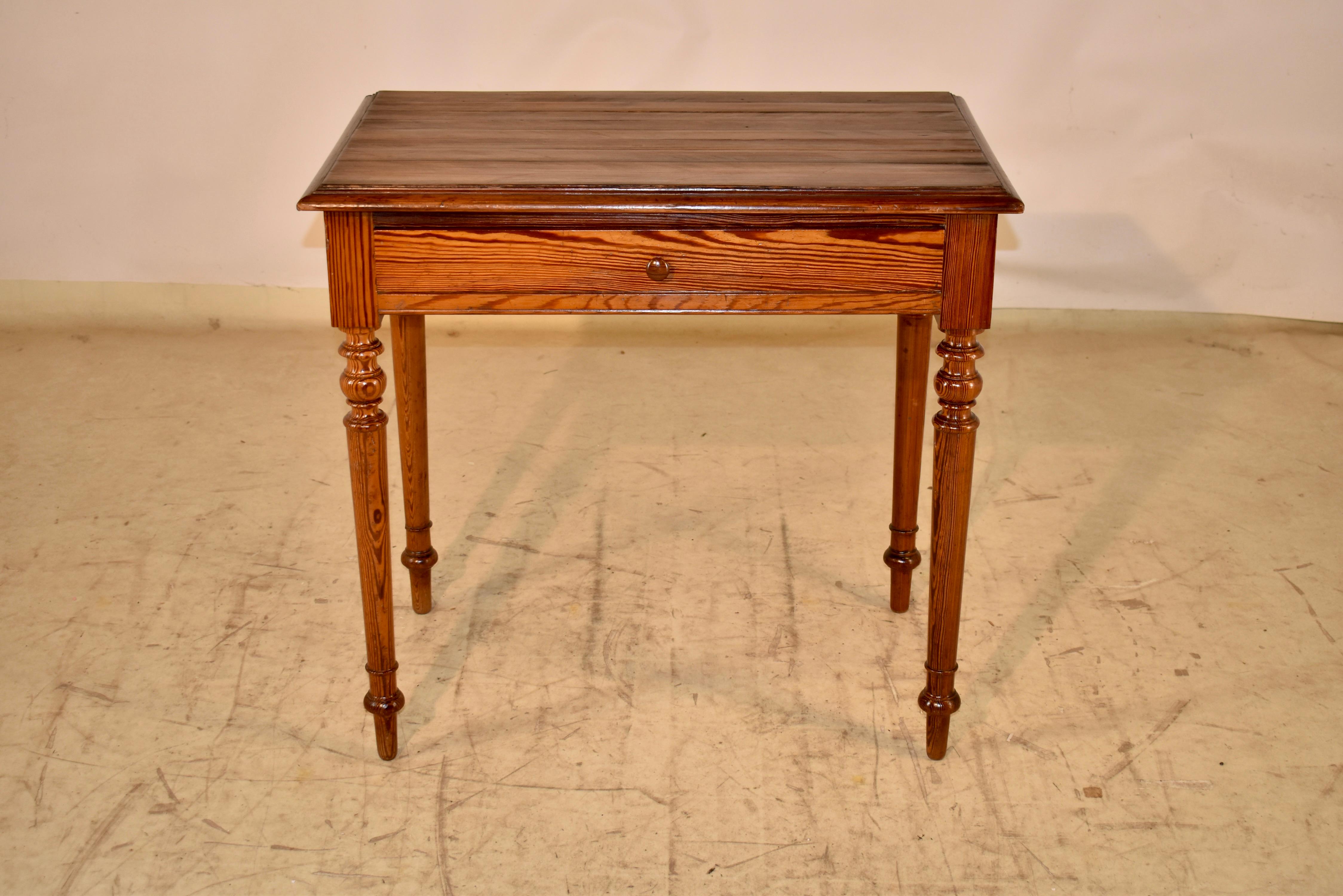 19th century pitch pine side table from France.  The top is richly grained and has a molded and beveled edge, which adds loads of dimension.  The top follows down to an apron, which is simple and contains a single drawer in the front of the piece. 