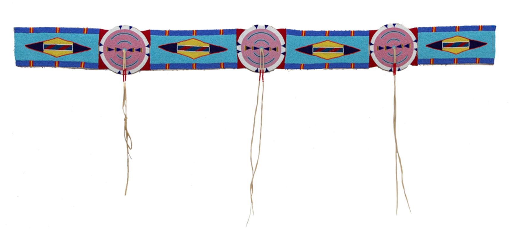 Esta antigua tira de manta con cuentas Crow del siglo XIX es un impresionante ejemplo de la artesanía de los indios de las Llanuras. Esta pieza, fabricada con piel curtida por los nativos y adornada con cuentas de vidrio y tela roja, presenta un