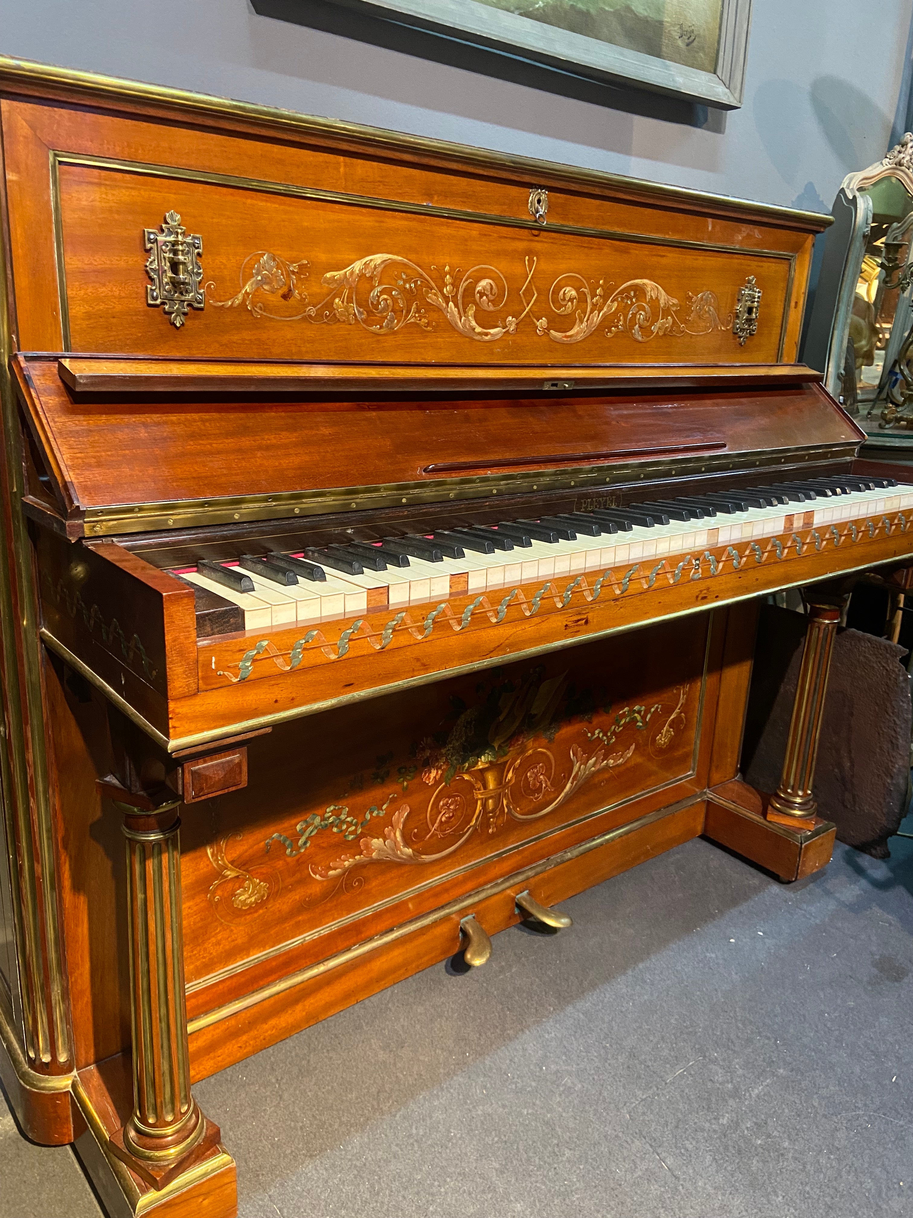 This rare upright piano was made by Pleyel in France in September 1871 according to the Pleyel Archives found at Musée de la Musique.
The natural wood cabinet is beautifully decorated with hand painted floral garlands. The piano sides are square