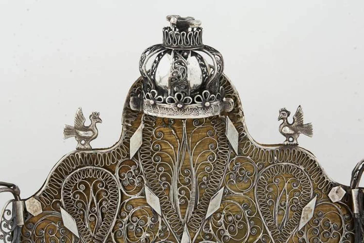 Silver and silver filigree Hanukkah Lamp Menorah, Poland or Ukraine, 19th century. 
Mainly decorated with silver filigree, topped by a crown with three birds (one above the crown and two flanked below), and ewer-formed oil holders. Hanukkah lamps of