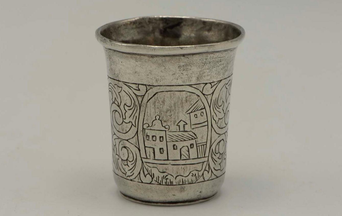 Engraved silver Kiddush cup, Poland, circa 1840. 
On a flat base with floral decoration and with two village scenes engraving, one of the village scene depicting a tower with a similar design as the Polish spice towers from the 19th century.
Marked