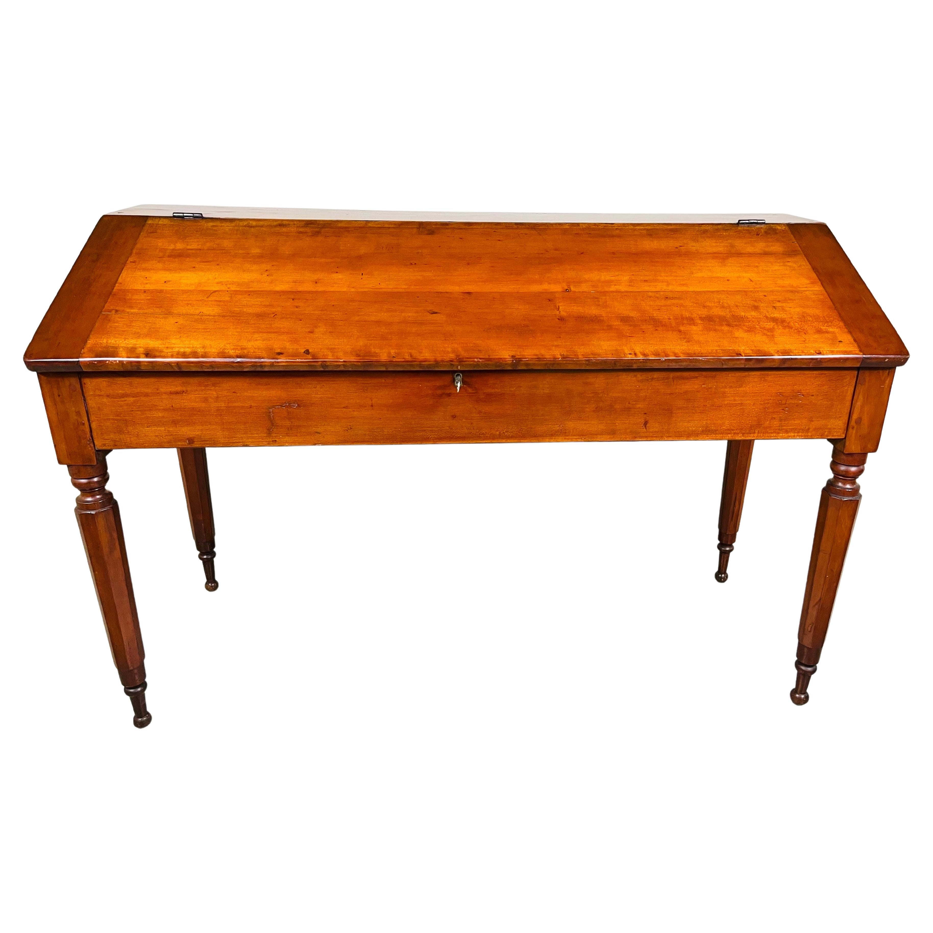 A stunning piece of history in this circa 1860 American Slant Front Schoolmasters desk constructed with Poplar wood with hand carved geometric legs that feature ball accents at the top and feet. Original lock is present with original key but does