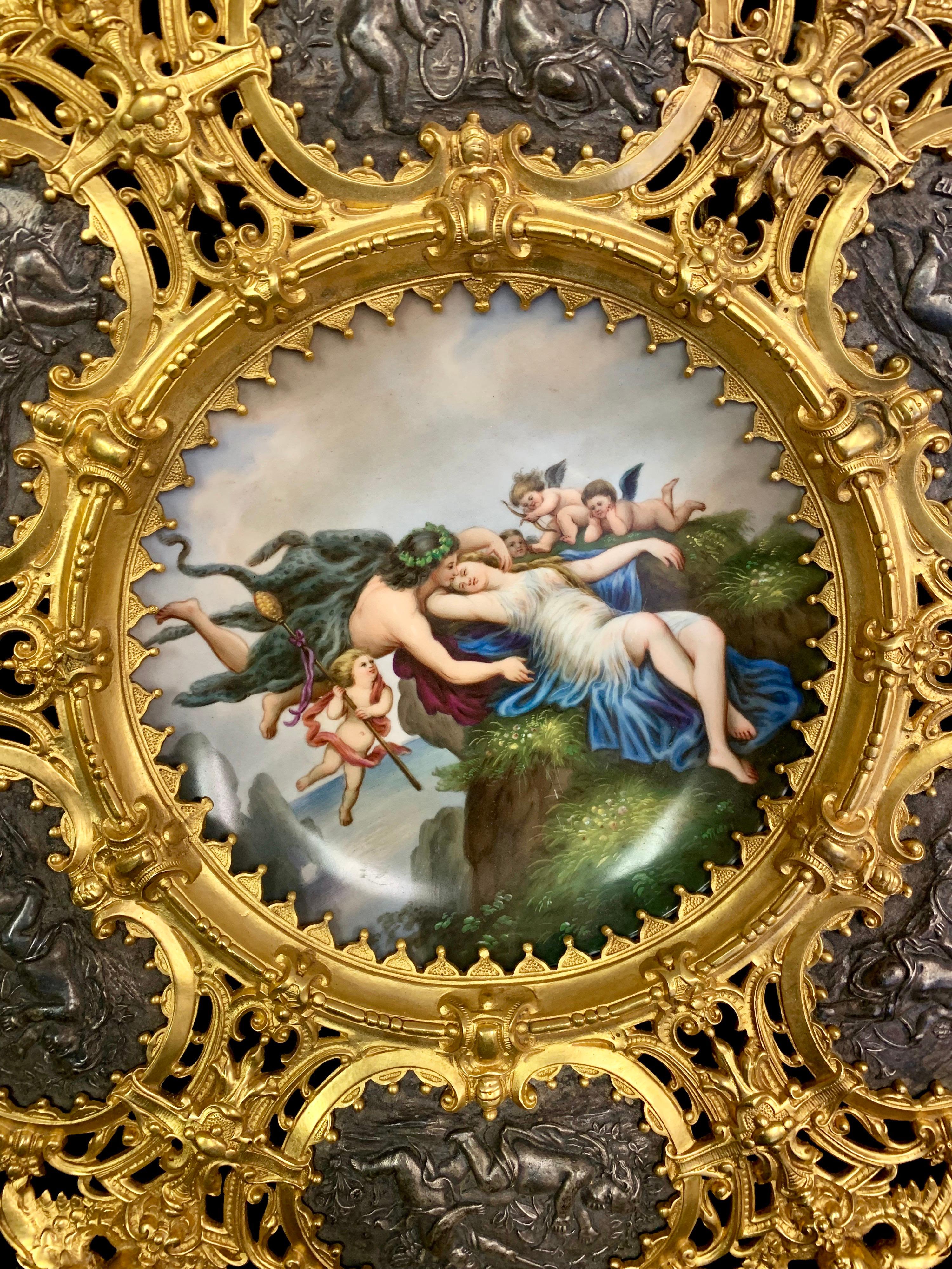 A lovely 19th century Austrian hand painted porcelain plate depicting a young lady reclining on a cliff and being saved by a young man and cupids. Within a magnificent patinated and gilt bronze frame.