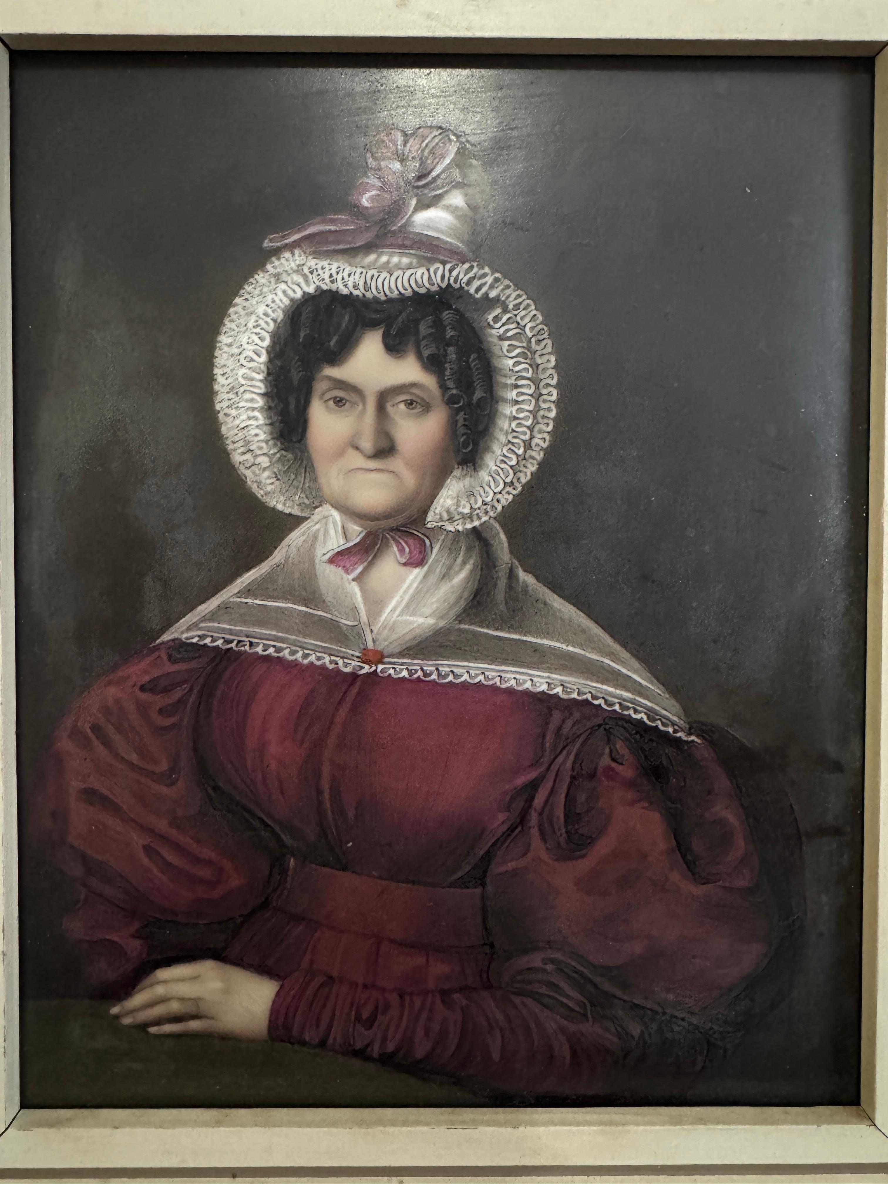Plaque de portrait en porcelaine du XIXe siècle, représentant une femme austère portant une coiffe et une robe rouge, peut-être une matrone.  

Taille de la plaque - 7.5
