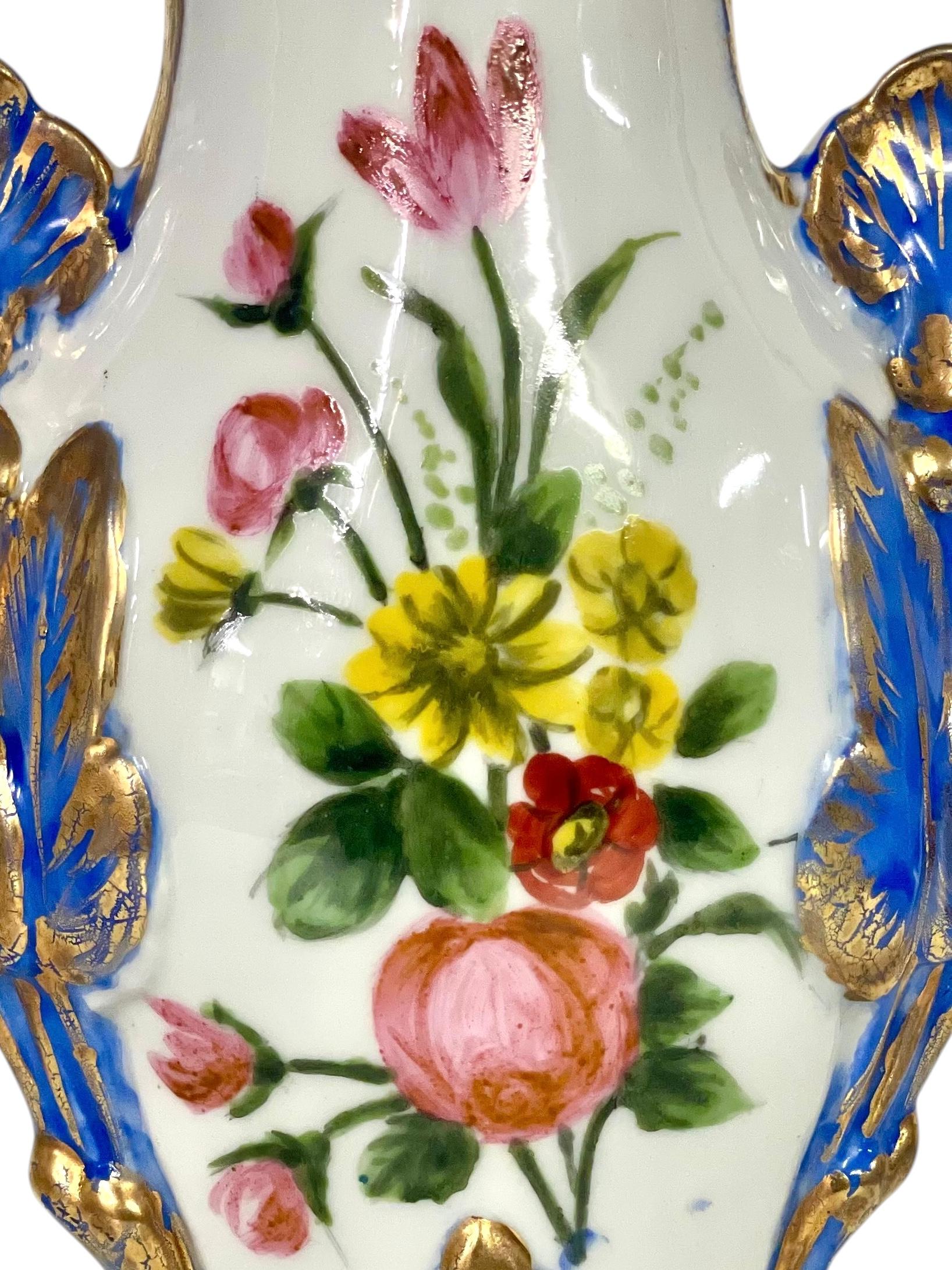 Questo vaso francese del XIX secolo è uno splendido esempio di porcellana dipinta a mano, tradizionalmente regalata come dono di nozze in Francia. La sua forma ispirata al Rococò presenta un design intricato e scultoreo con curve elaborate e