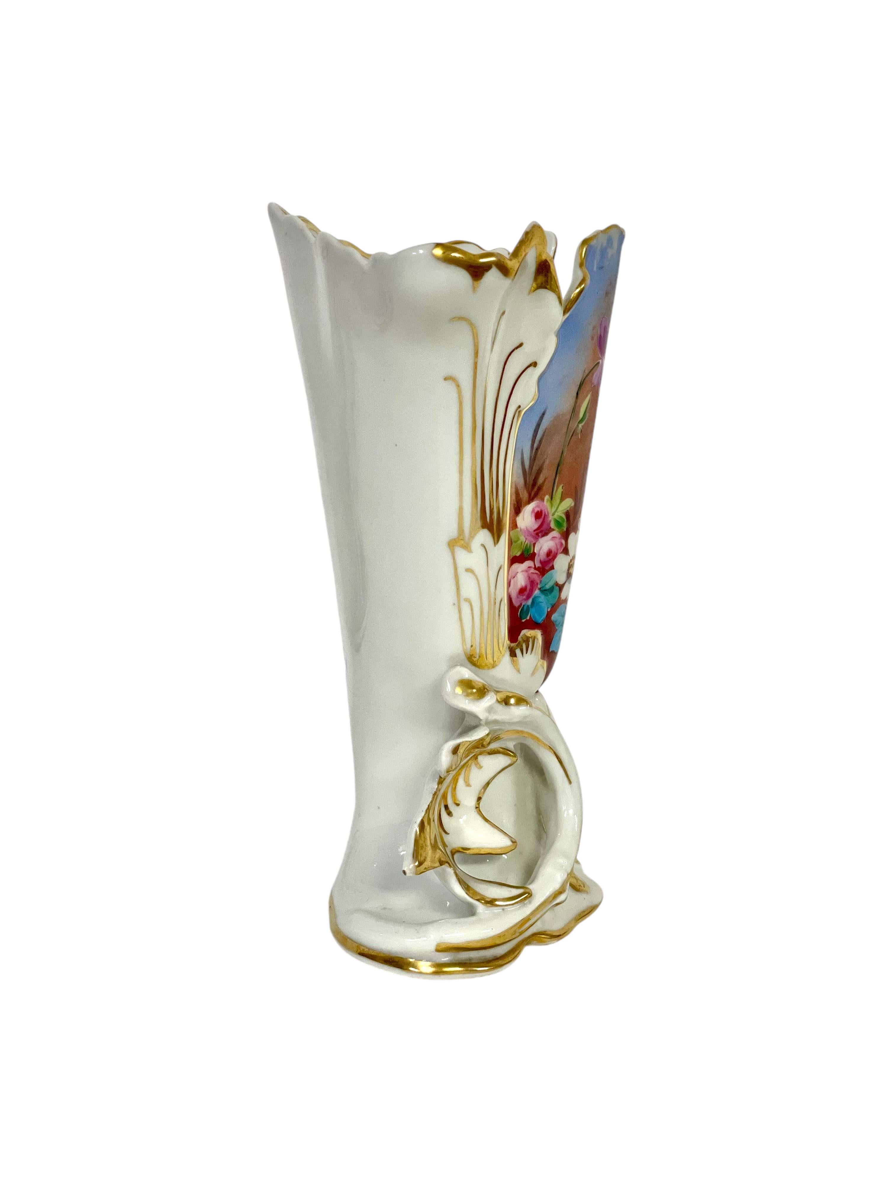 Uno squisito vaso nuziale in Porcelaine de Paris (o Vase d'Eglise Mariée), con un bordo ondulato dorato e una base esuberantemente modellata e dorata. Sul lato anteriore c'è una deliziosa scena floreale dipinta a mano con fiori di campo su un cielo