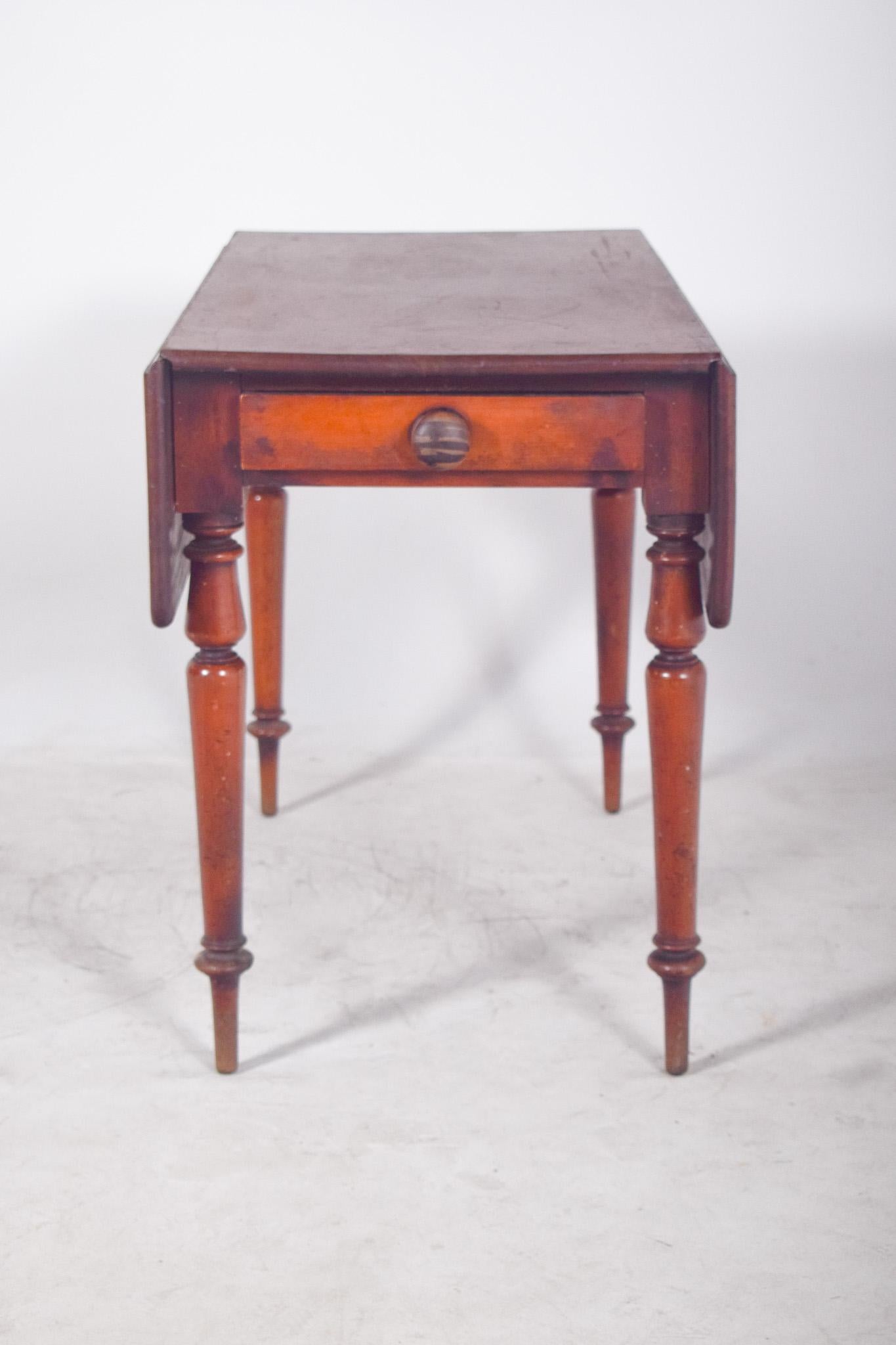 Side table with drawer. Made from solid wood and finished in a dark colour, the table stands out for its practicality and the classic elegance of its details.
With a rectangular top, it has two folding side flaps that can be lifted up to extend the