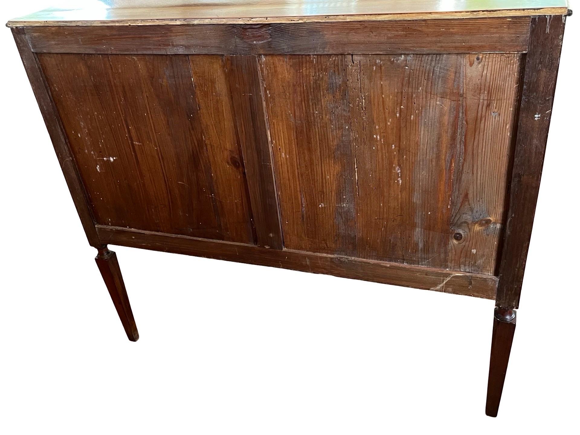 Louis XVI commode hand-made in Portugal in the early 1800s using mahogany and decorated with mahogany and fruitwood veneer. The commode features three rows of inset drawers; the top row is divided into three smaller drawers, whereas the bottom two