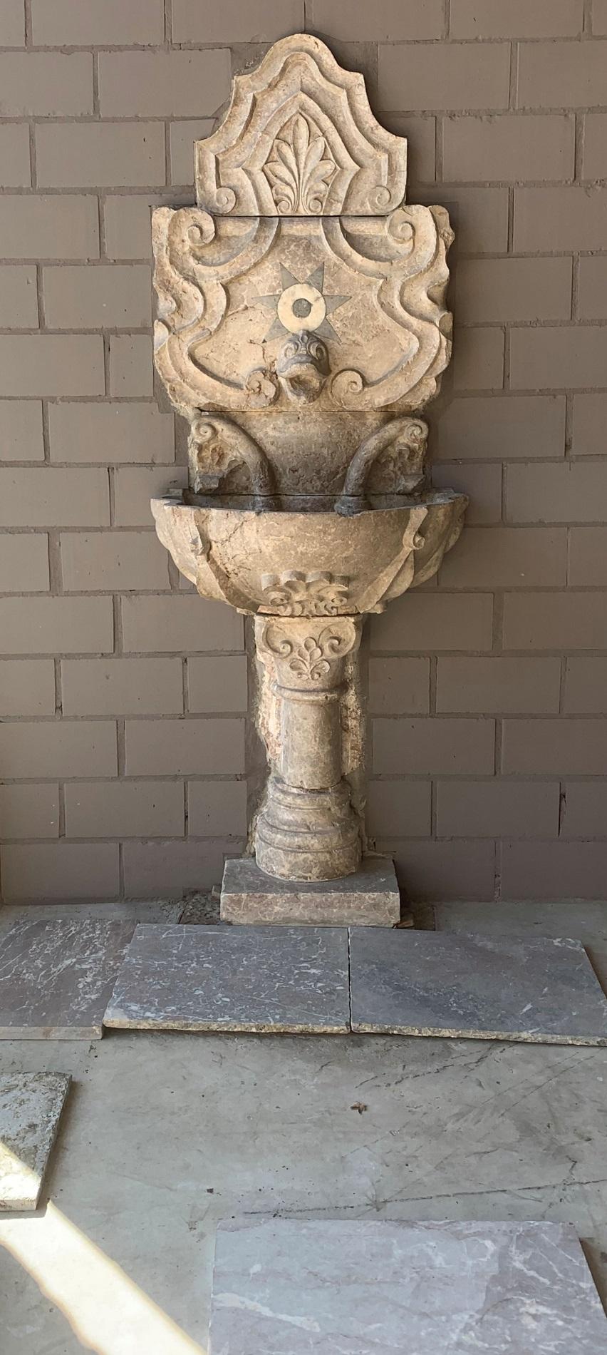 A large 19th century Portuguese wall fountain. Finely sculted in Verona marble with a moulded star inlayed plint above the lobbed basin resting on a baluster plint. The dolphin snout beautifully sculted out of the same black marble as the intarsia