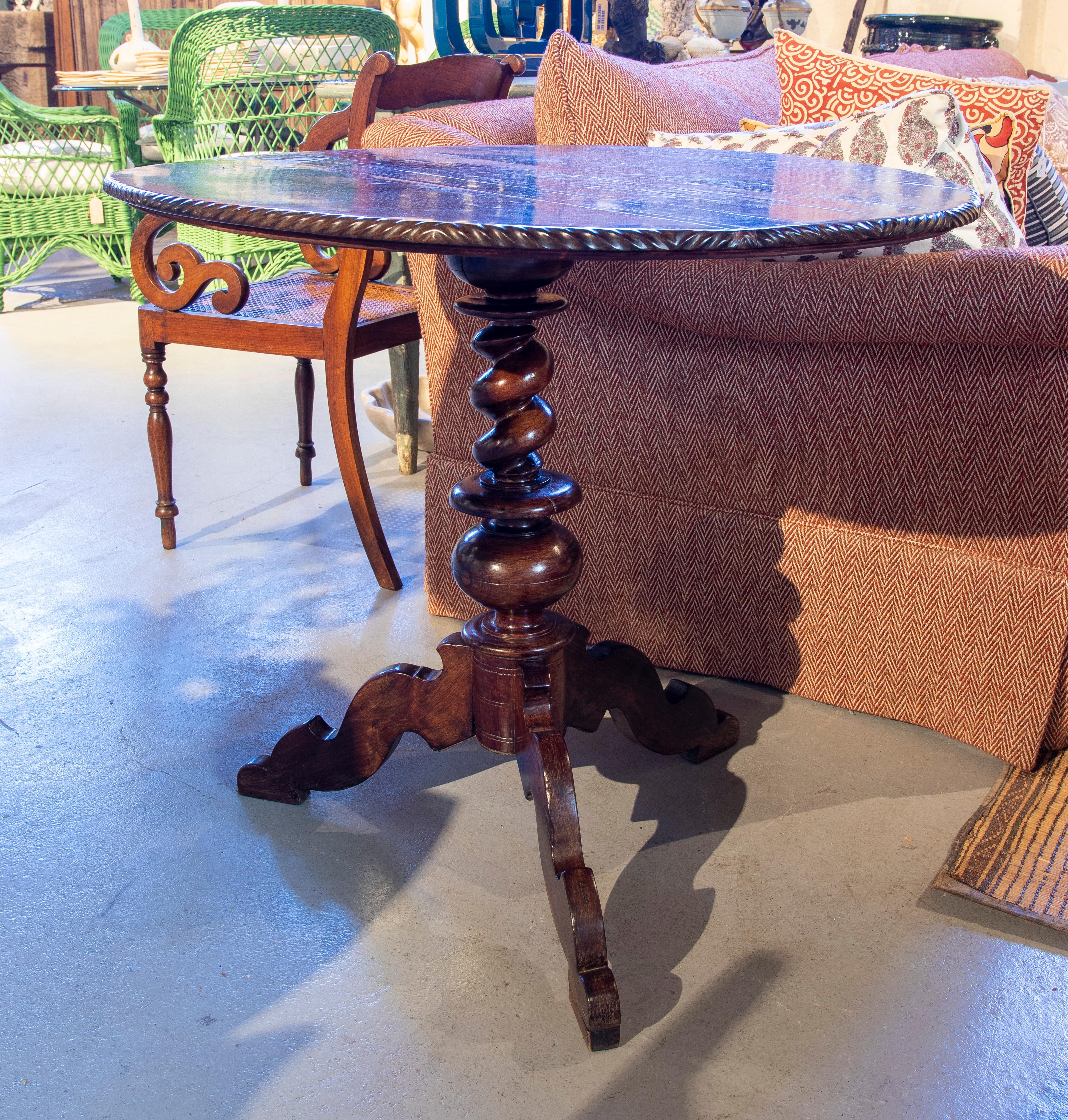 19th century Portuguese rosewood table with oval top and leg in the middle.