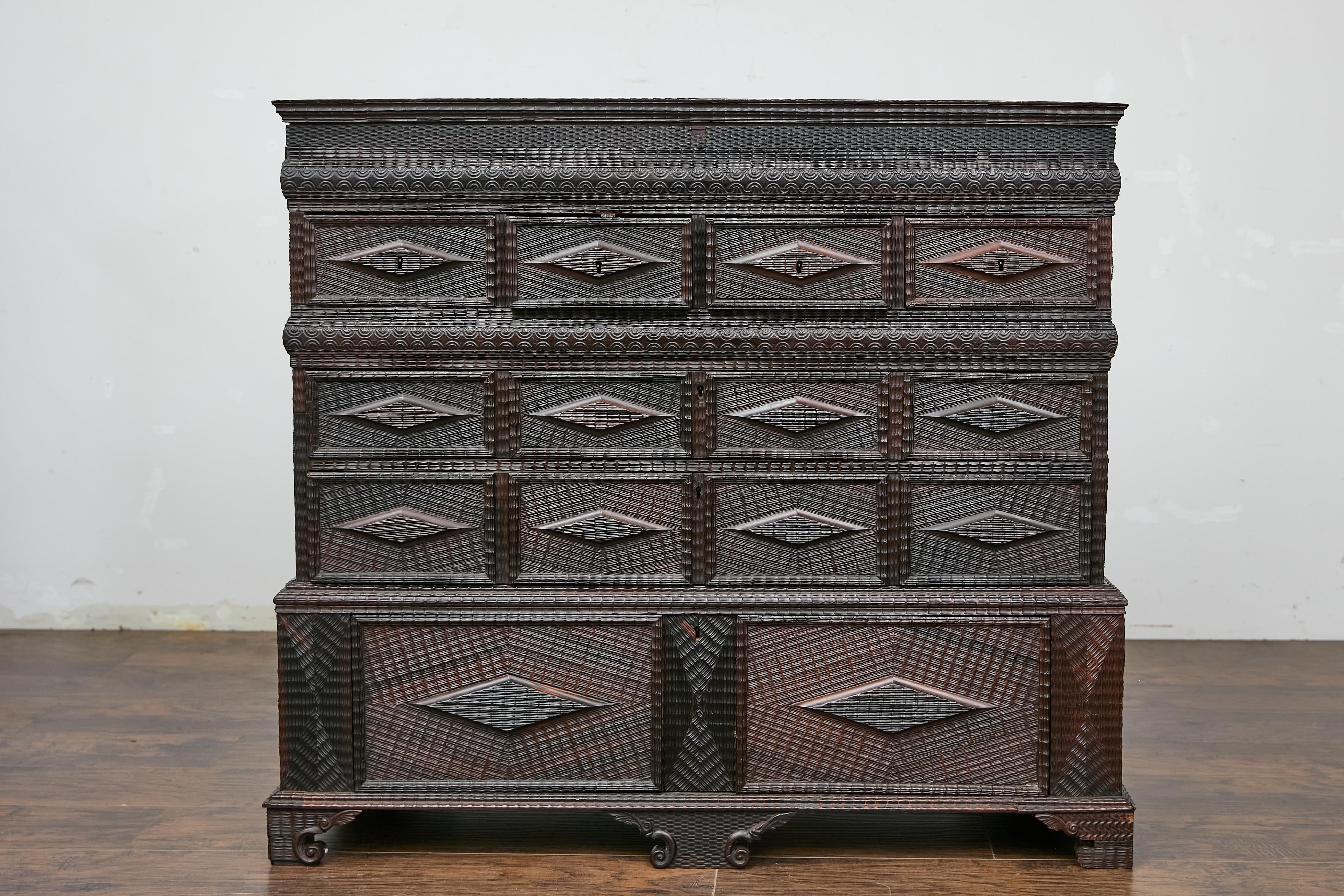 Cassapanca portoghese Tramp Art del XIX secolo con decori in rilievo intagliati a mano, piano rialzato, scomparti nascosti e patina scura. Questa cassapanca portoghese Tramp Art del XIX secolo affascina con i suoi intricati decori in rilievo