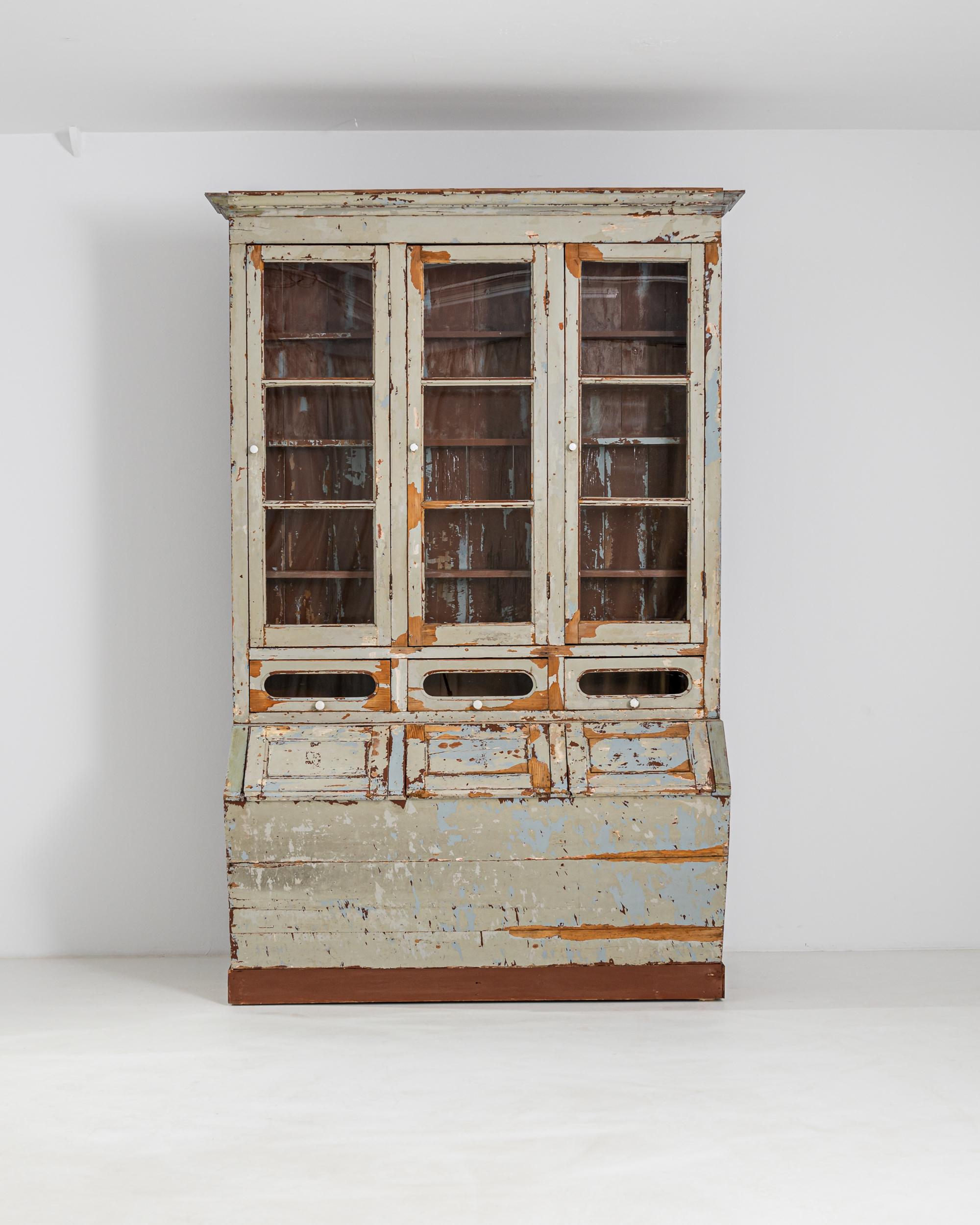 The unusual shape and evocative patina of this antique wooden vitrine makes it a find to treasure. Built in Portugal in the 19th century, the topcoat of the paint has weathered over the years to create a dynamic composition of lichen green, soft