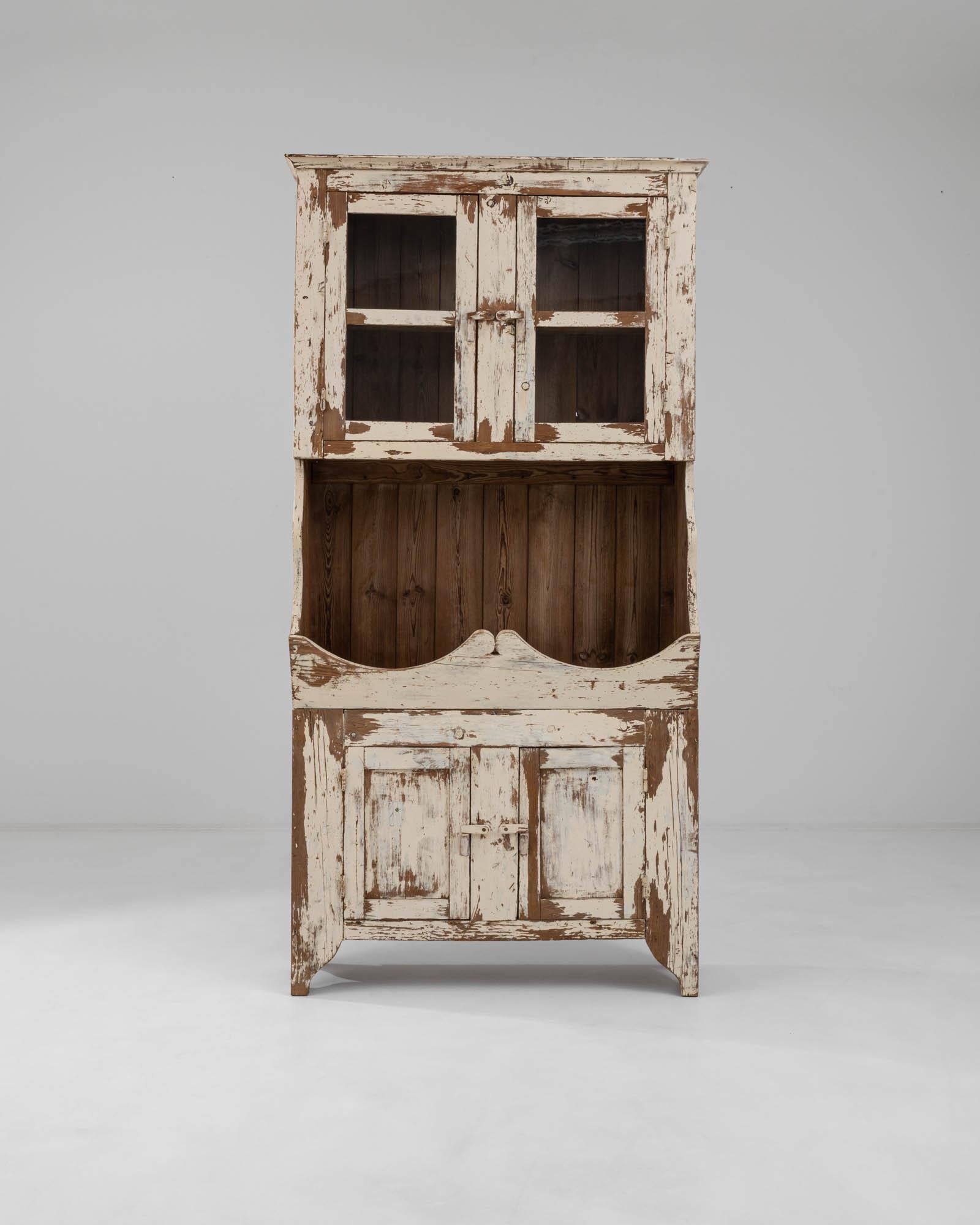 Exuding the warm playfulness of Southern Europe, this authentic vitrine was hand-crafted in 19th-century Portugal. The traditional buffet cupboard structure is reimagined by integrating the original display shelf in the center. The flowing outlines