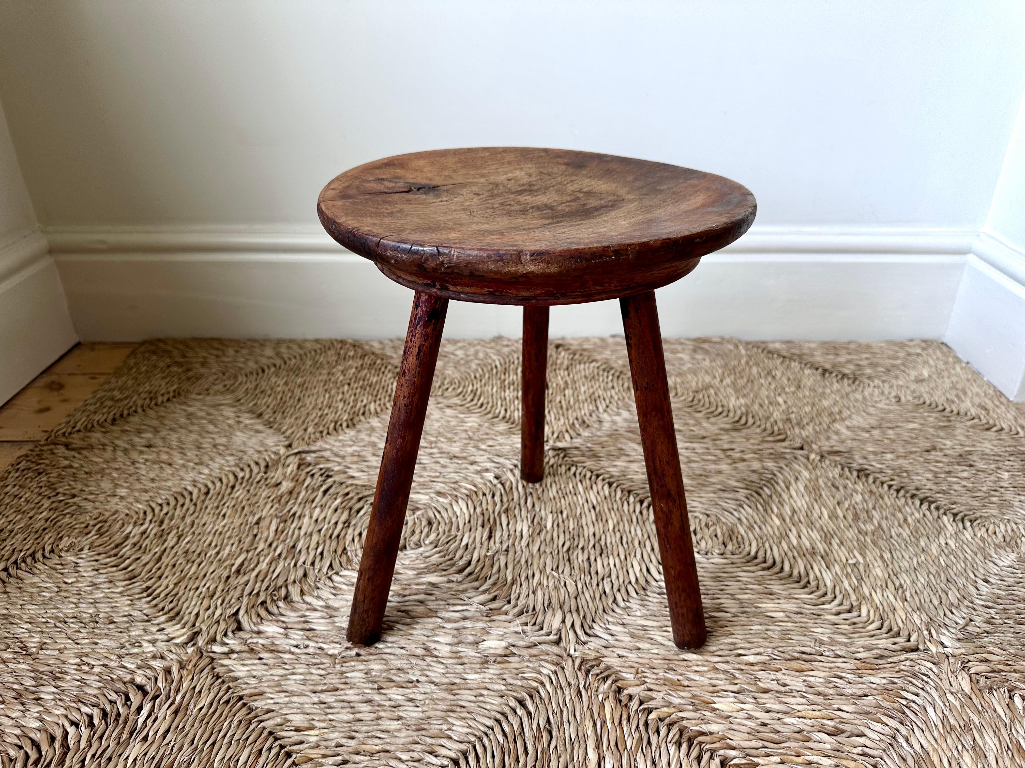 Primitive Welsh vernacular tripod dairy stool dating from the 19th century.

A simple jointed tripod stool, typical of rustic Welsh furniture from the 18th-19th century.

A beautifully worn carved wood seat and splayed legs. Great colour with patina